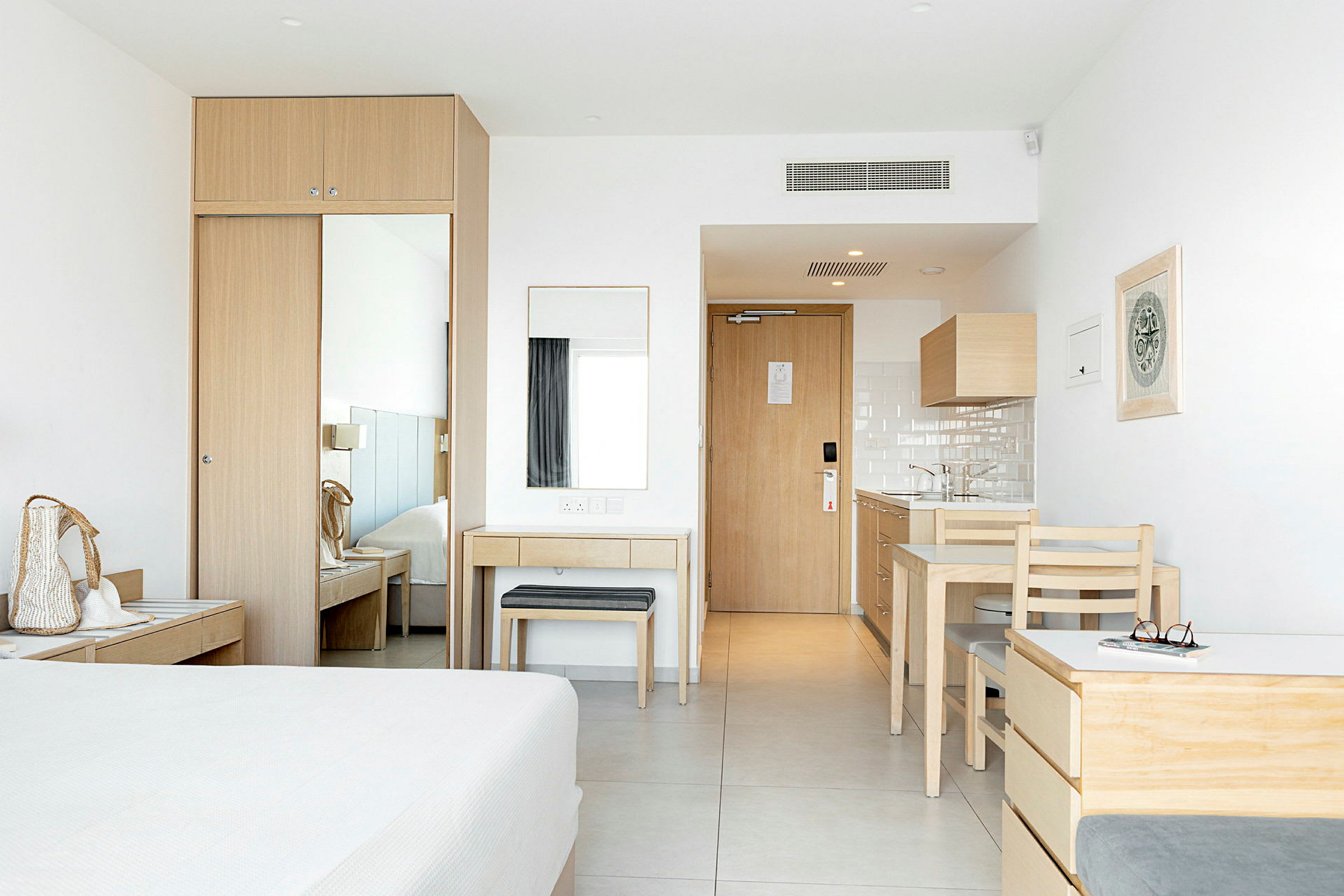 Ett hotellrum med ljus inredning och möbler i trä. (AI-genererad text)