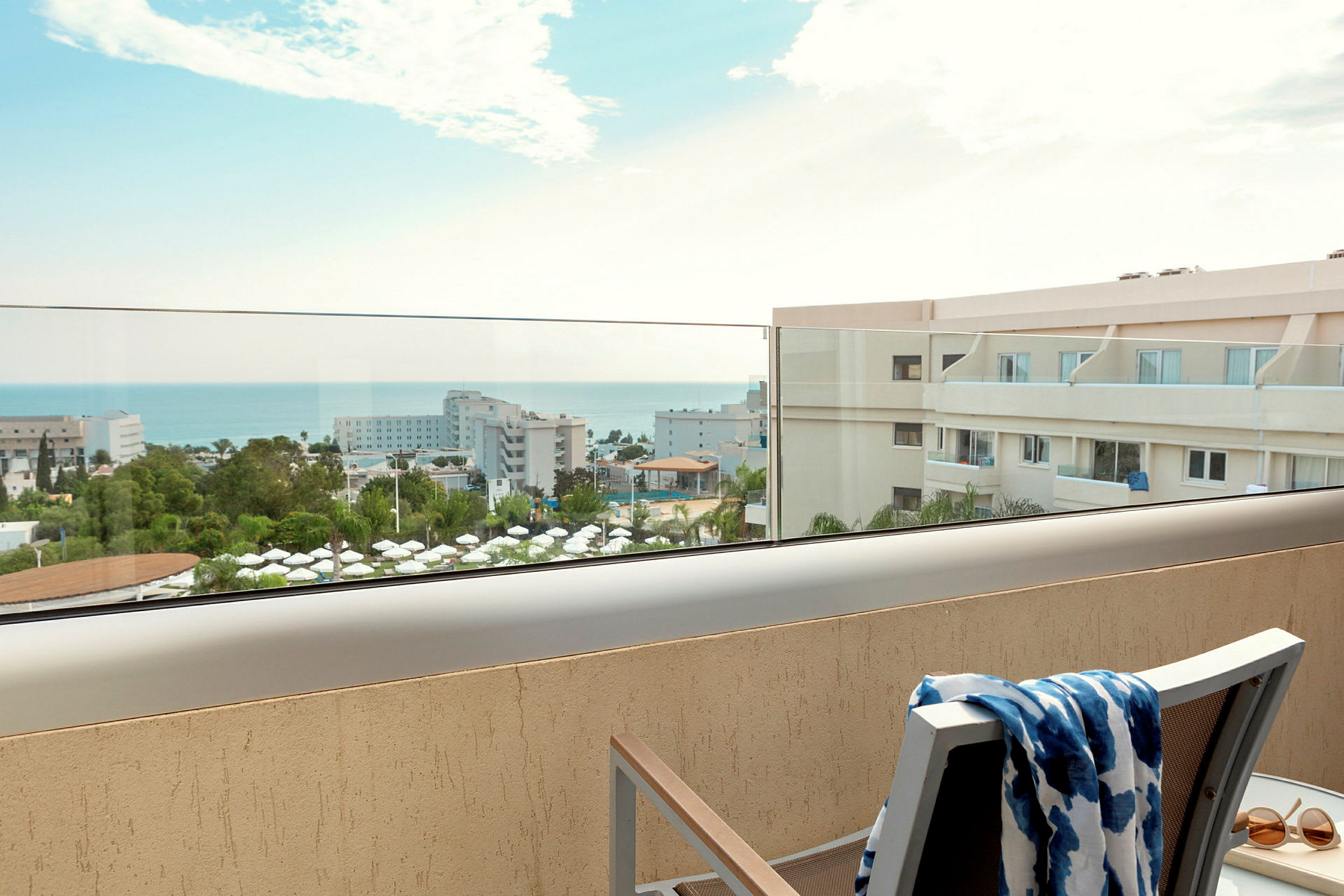 Utsikt från balkong över hotellområde och hav. (AI-genererad text)