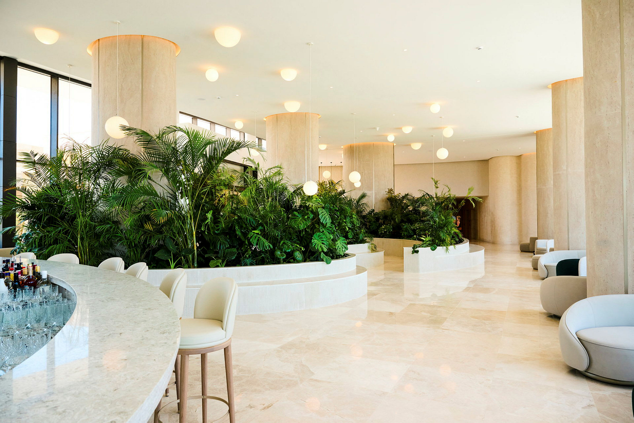 Hotellets lobby med moderna, ljusa möbler och grönskande växtarrangemang. (AI-genererad text)