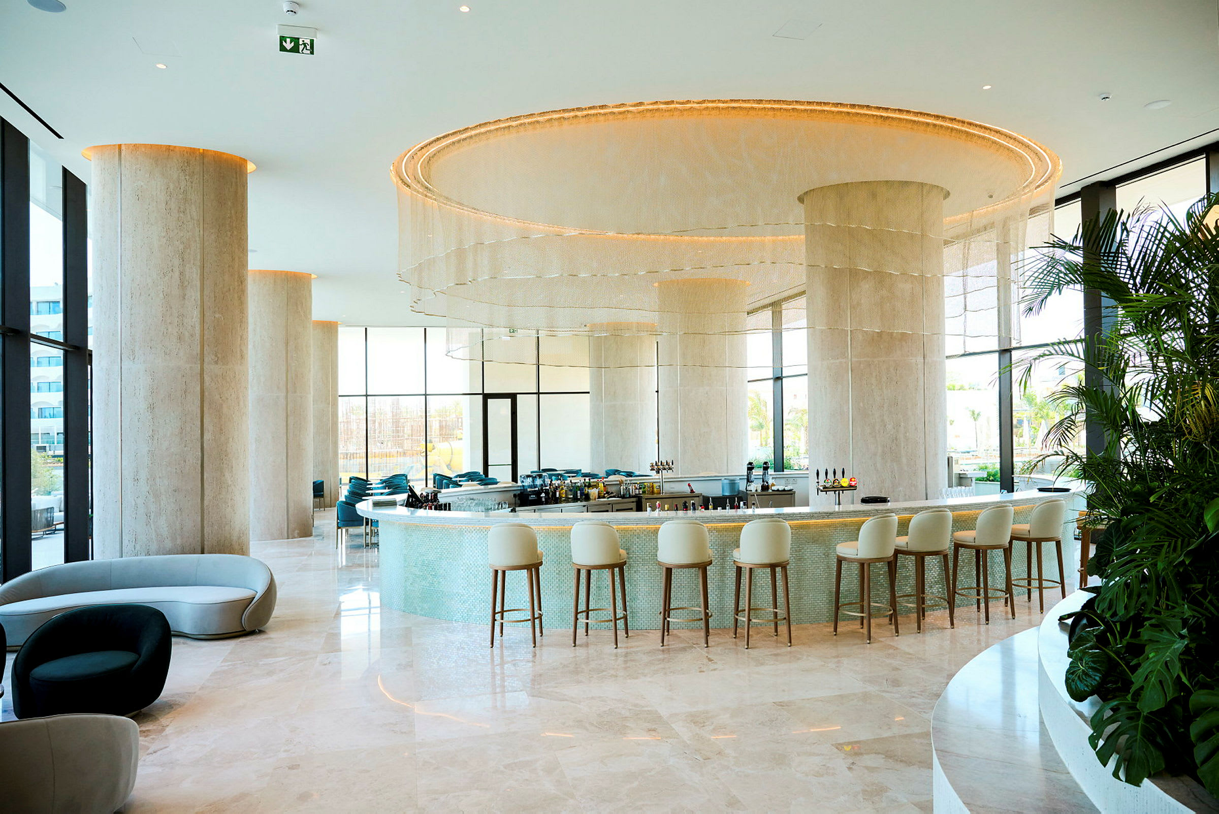 En elegant hotellbar med modern inredning, höga stolar och ljusa färger. (AI-genererad text)