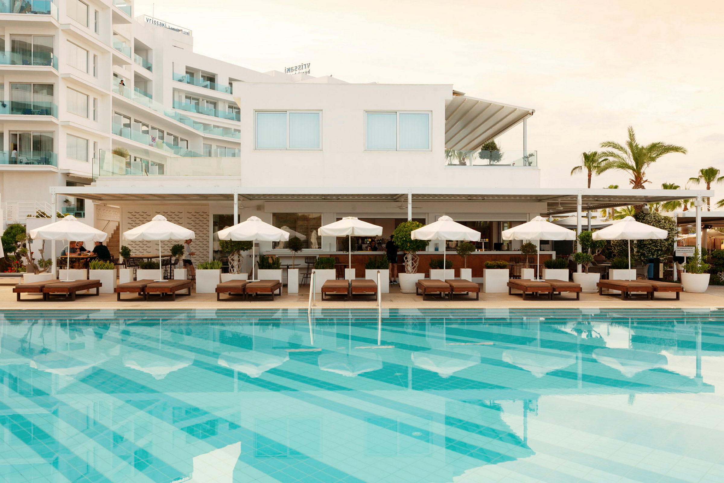 Hotell med pool, solstolar och parasoller. (AI-genererad text)