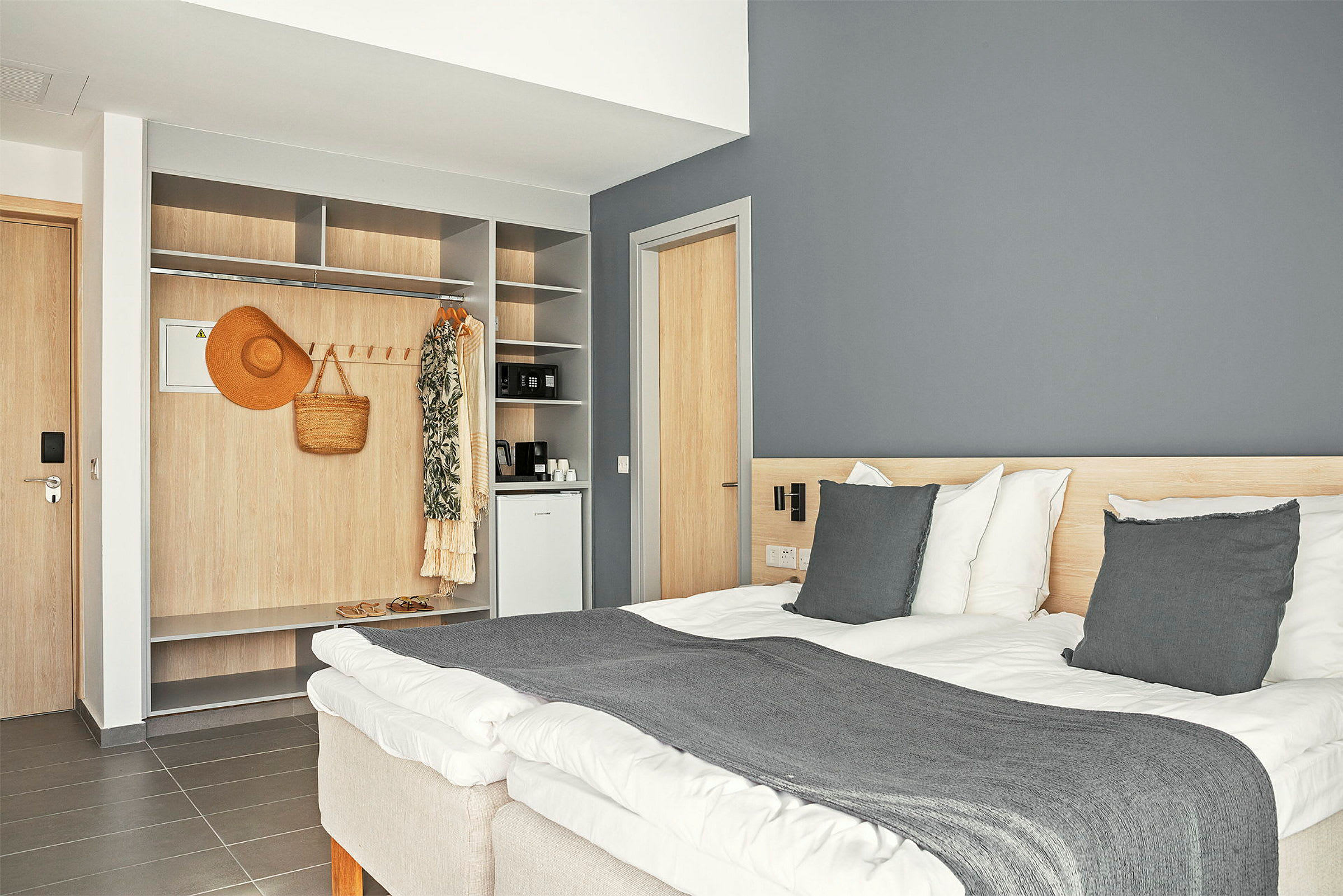 Hotellrum med en dubbelsäng, en inbyggd garderob och en mini-kyl. (AI-genererad text)