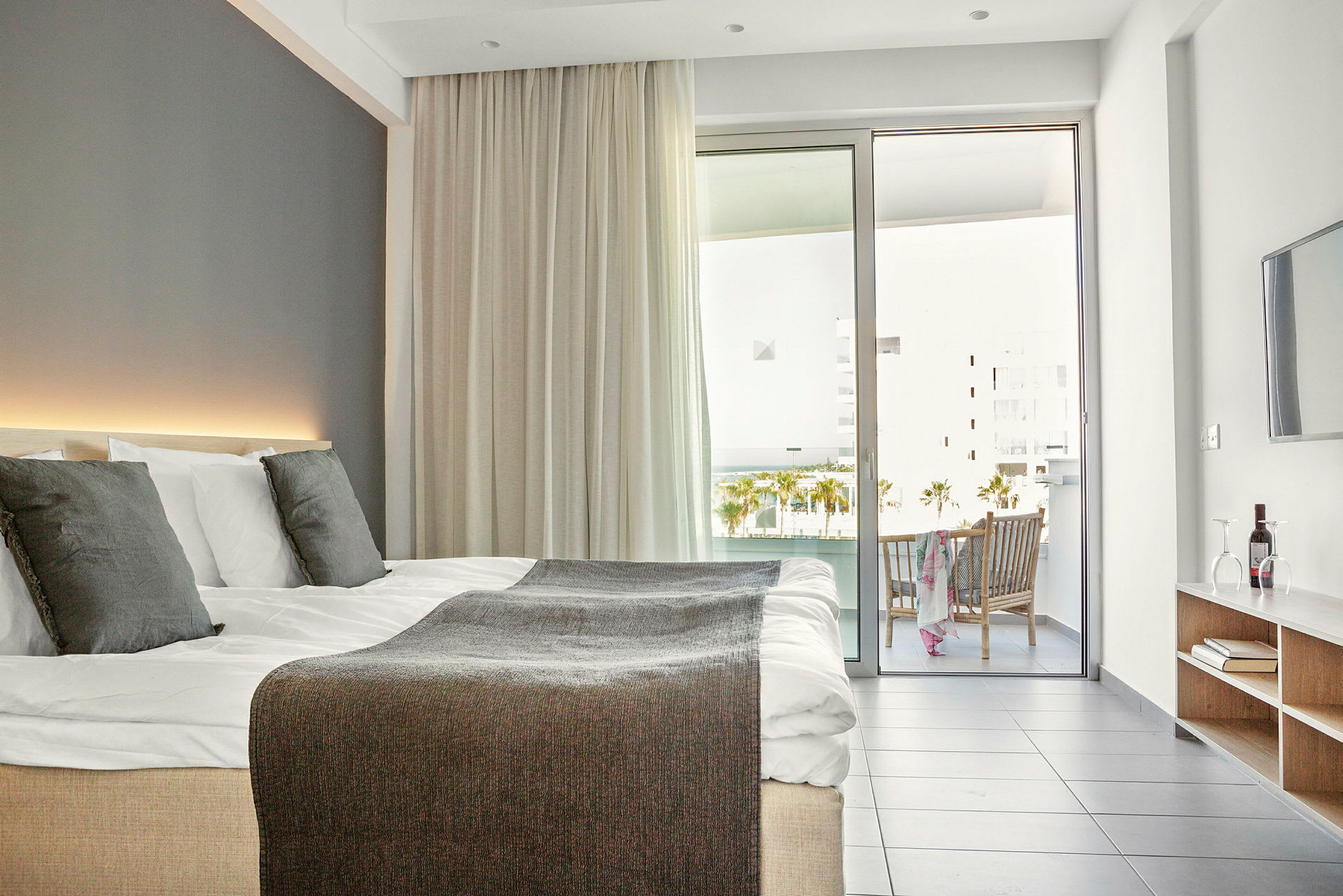Modernt hotellrum med dubbelsäng, balkong och sittgrupp. (AI-genererad text)