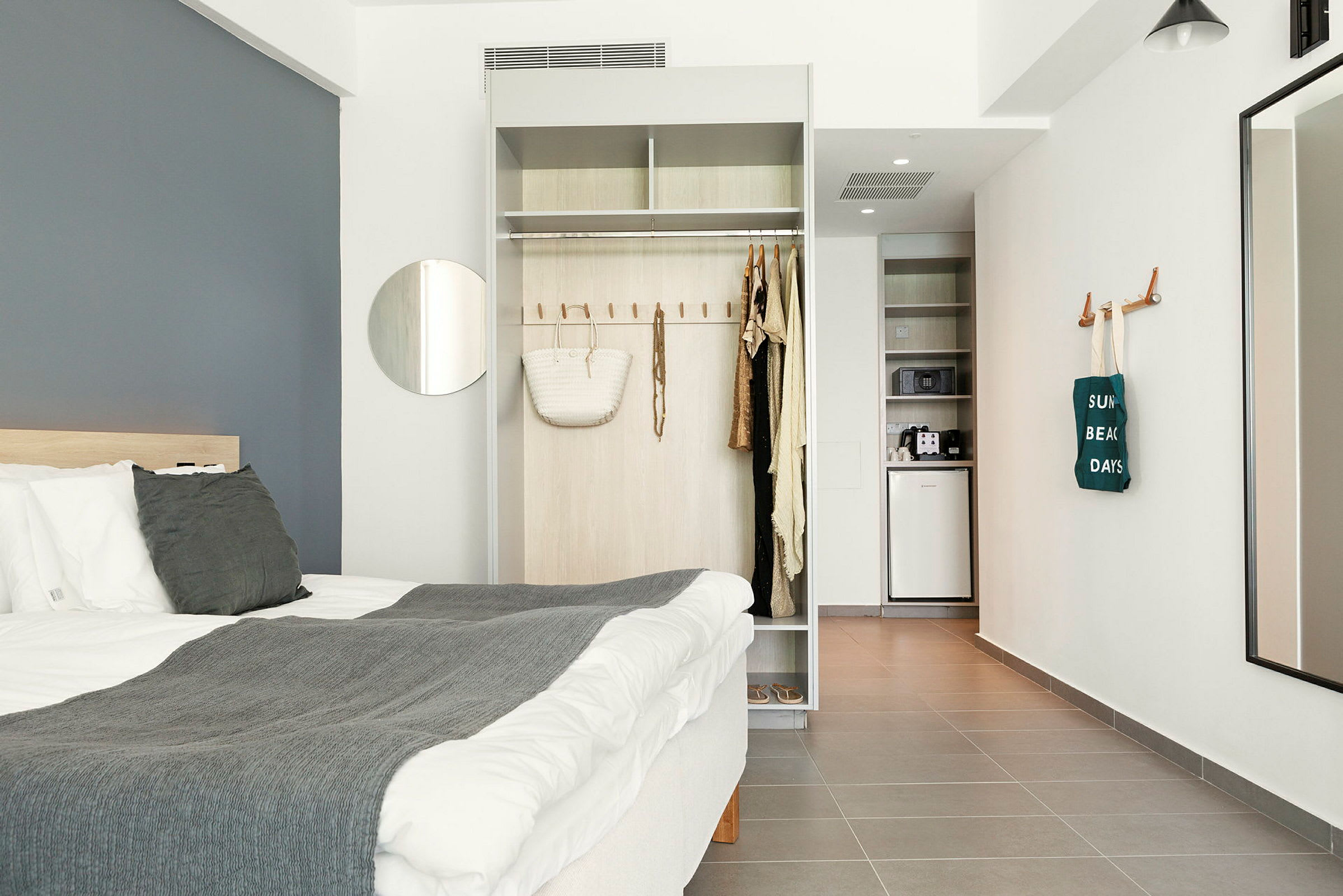 Modernt hotellrum med säng, garderob och litet pentry. (AI-genererad text)