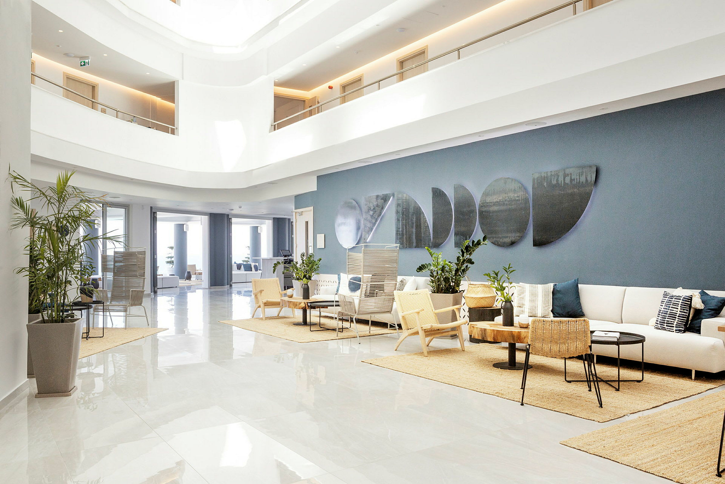 Hotellets lobby med ljus inredning, fåtöljer och soffor. (AI-genererad text)