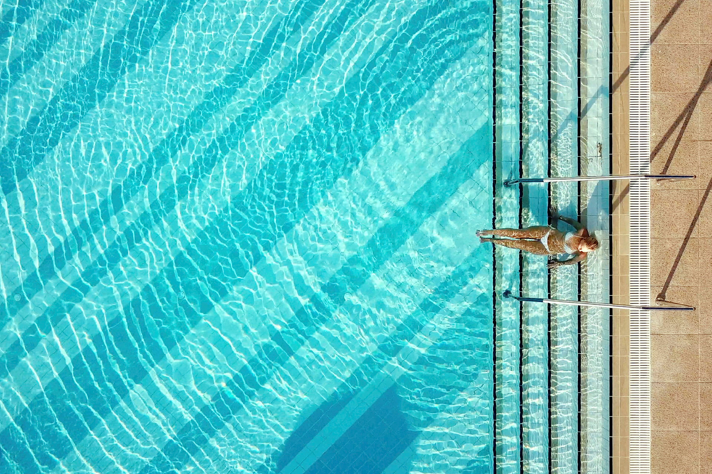 Person vid kanten av en swimmingpool. (AI-genererad text)
