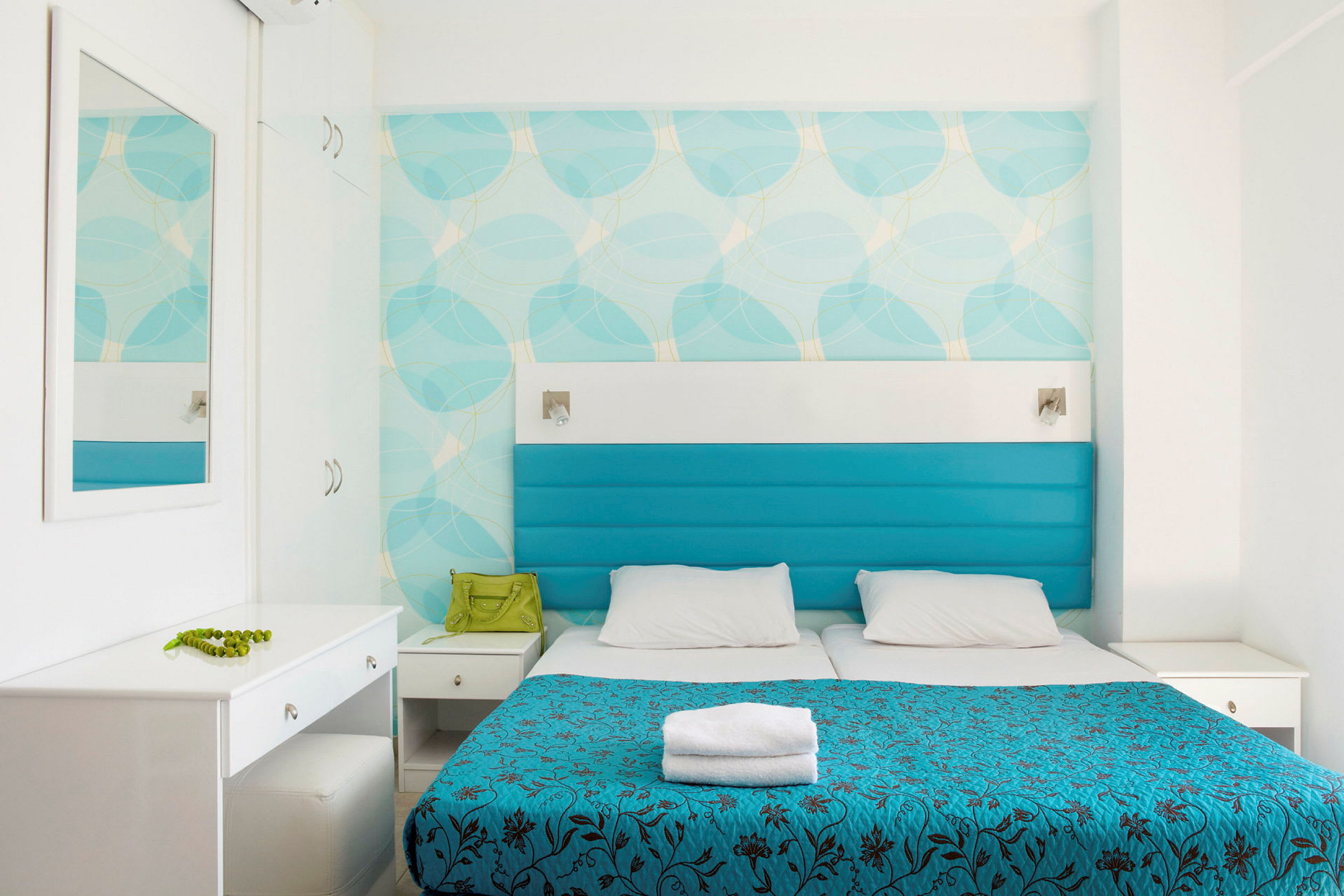 Ett hotellrum med två sängar, blå klädslar och en vit inredning. (AI-genererad text)