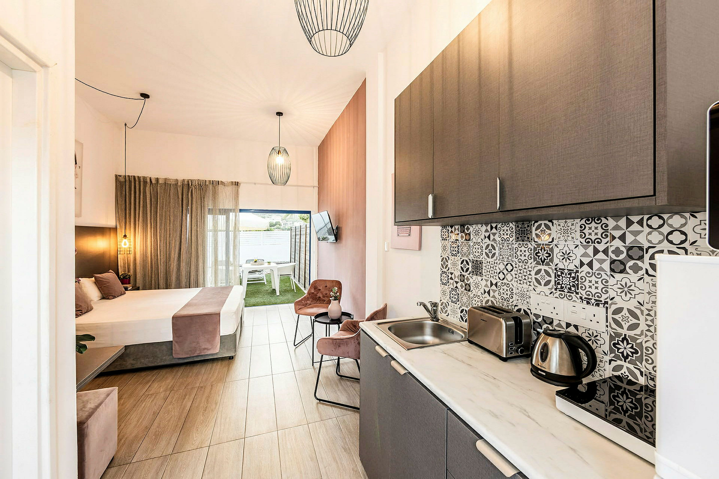 Bild av ett hotellrum med kök och sovplats, ljusa möbler och stilfull inredning. (AI-genererad text)