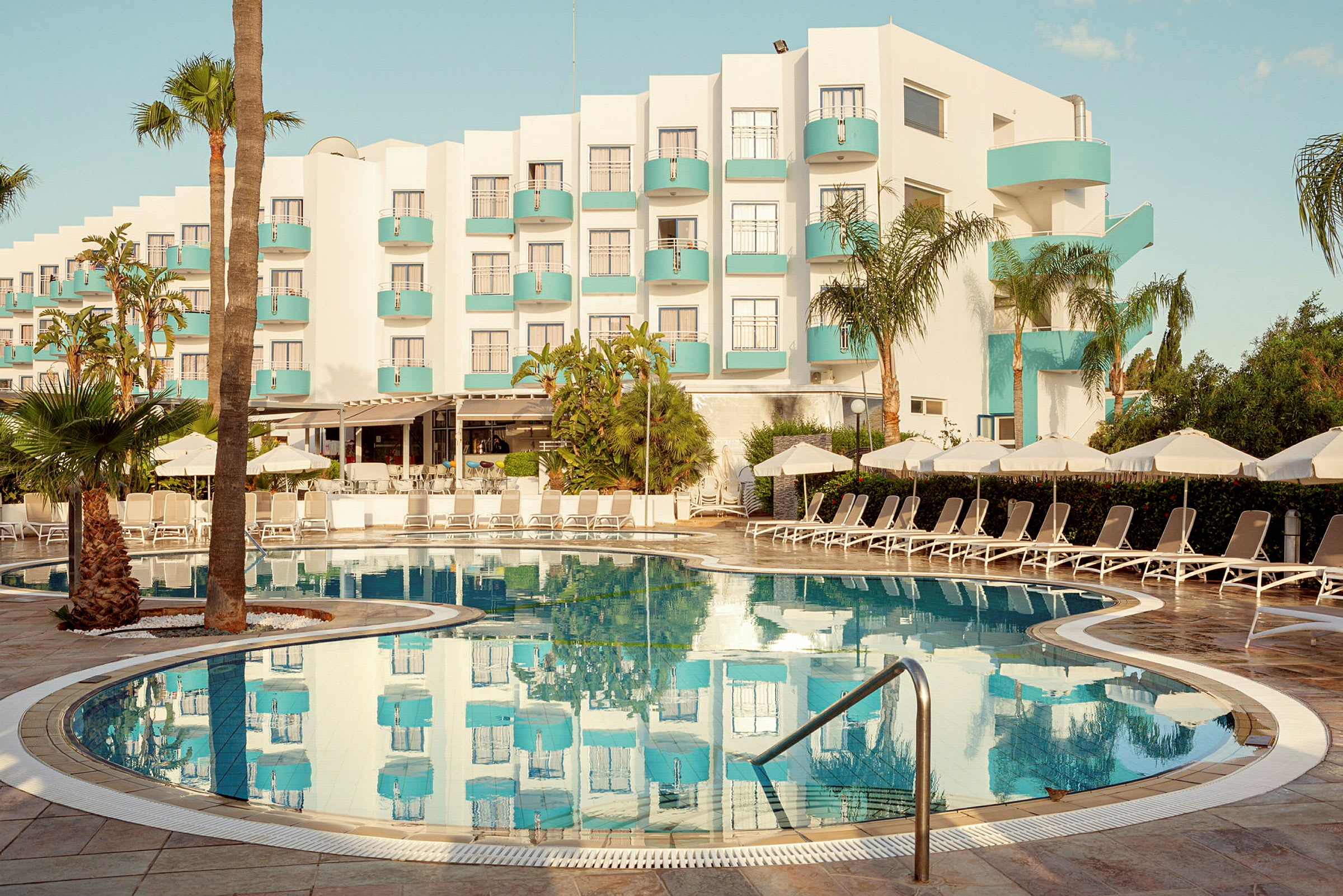 Hotell med modern design och pool i förgrunden. (AI-genererad text)