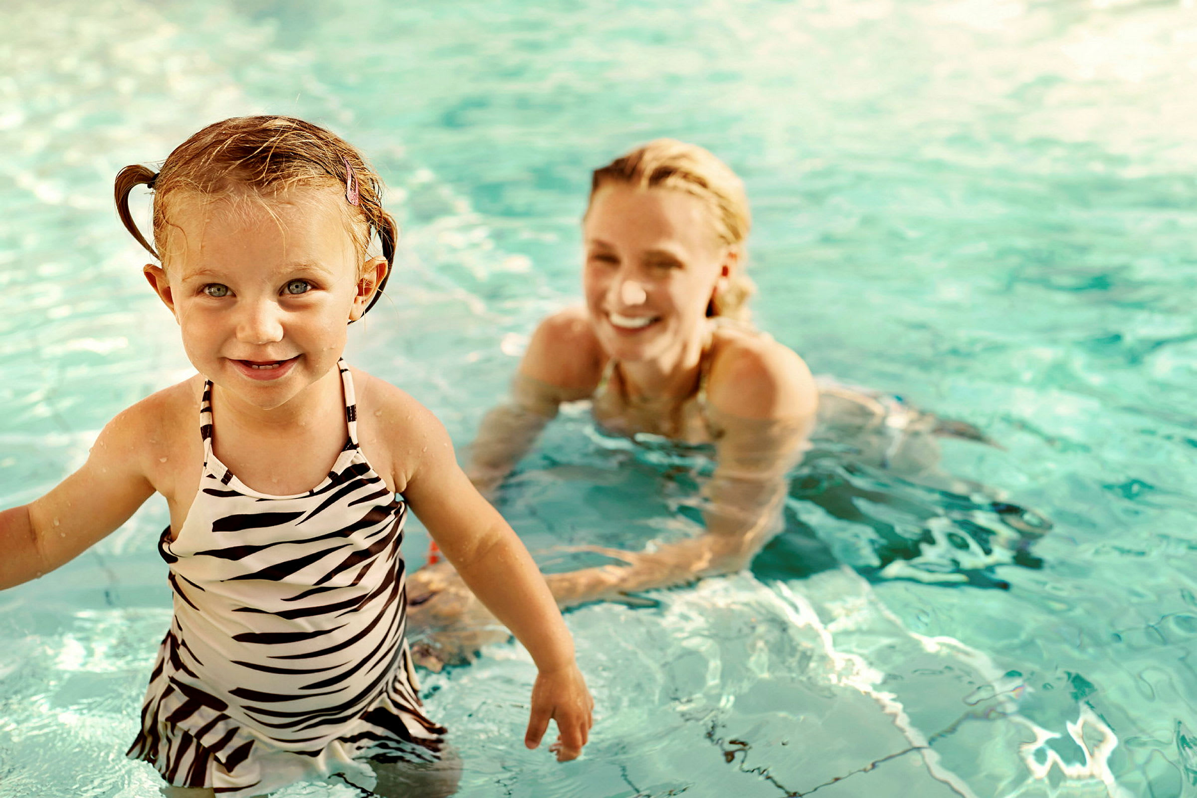 Ett barn i baddräkt leker i en pool. (AI-genererad text)