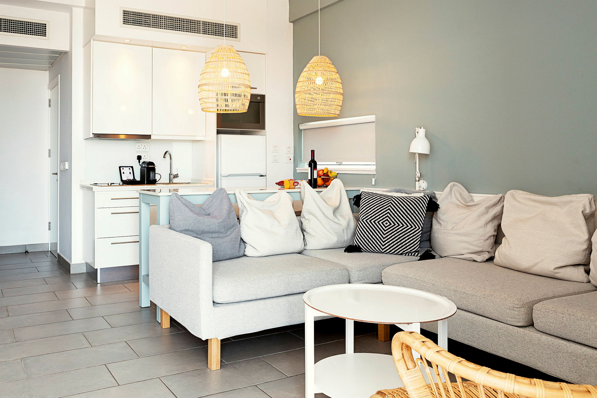En modern inredning med soffa, soffbord och ett kök i bakgrunden. (AI-genererad text)