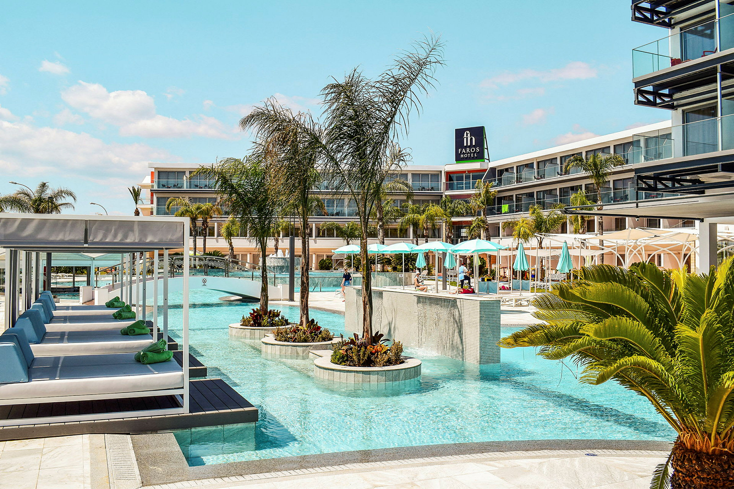 En modern hotellpool med solsängar och parasoller visar en avslappnande miljö. (AI-genererad text)