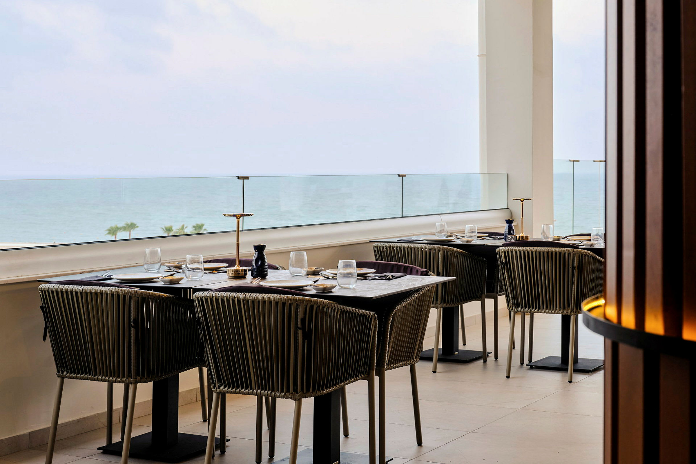 Ett uppdukat bord på en restaurang med havsutsikt. (AI-genererad text)