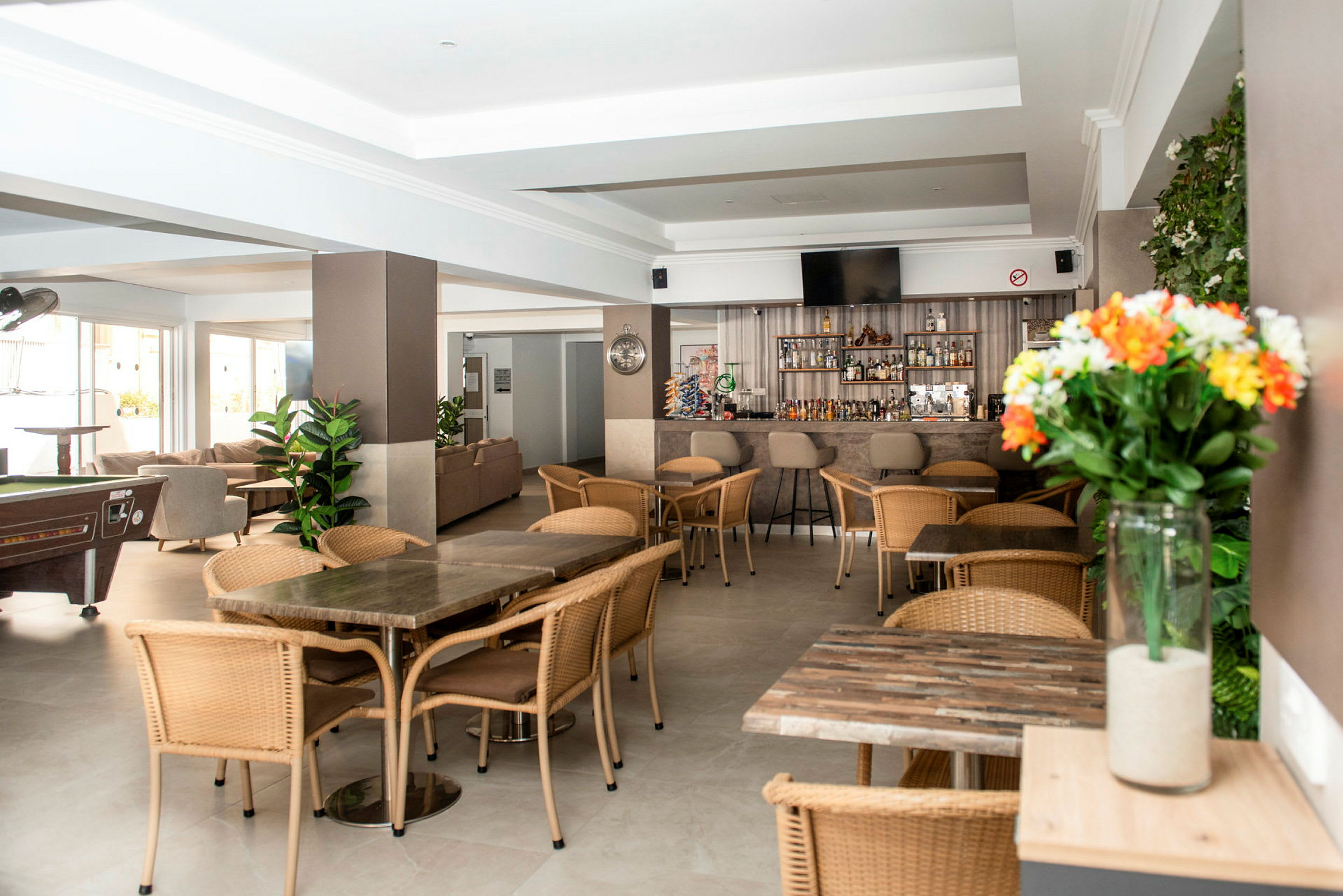 En lobby med sittplatser, bord och en bar. (AI-genererad text)