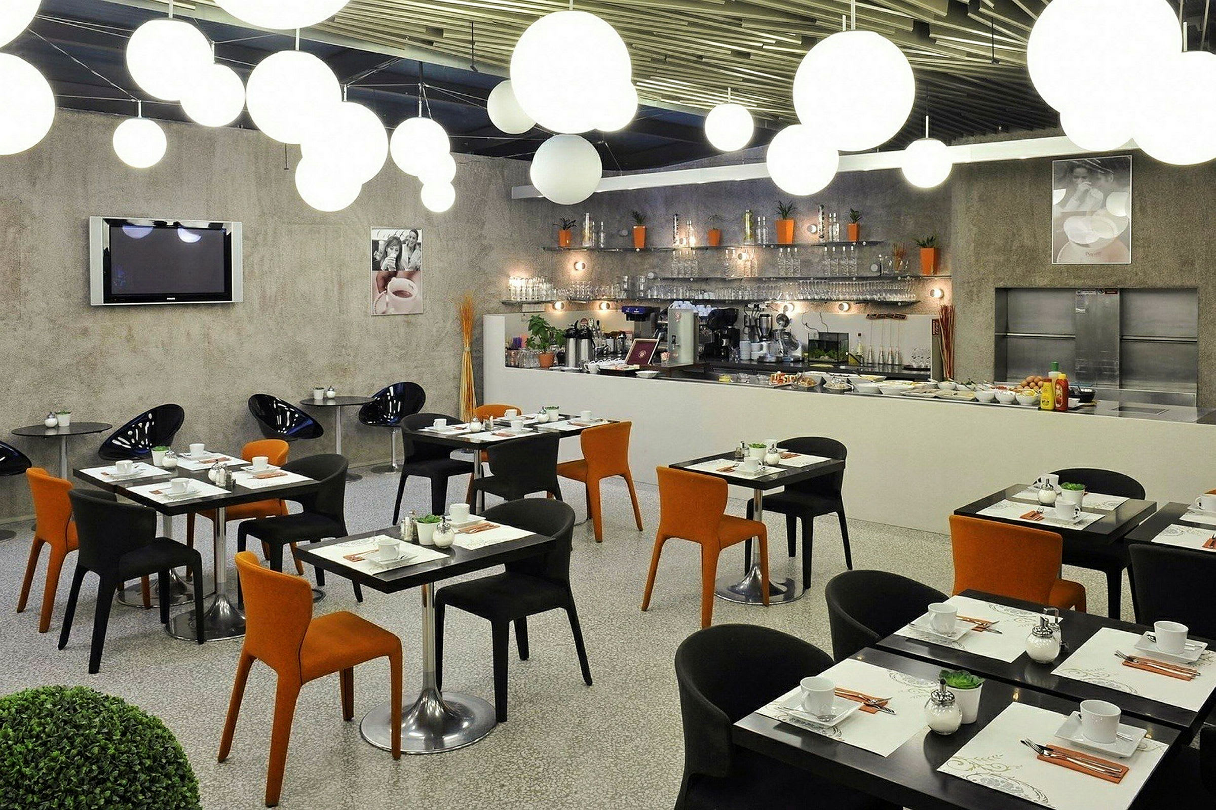 Moderna restaurangmöbler med svart och orange stolar samt förberett dukade bord. (AI-genererad text)