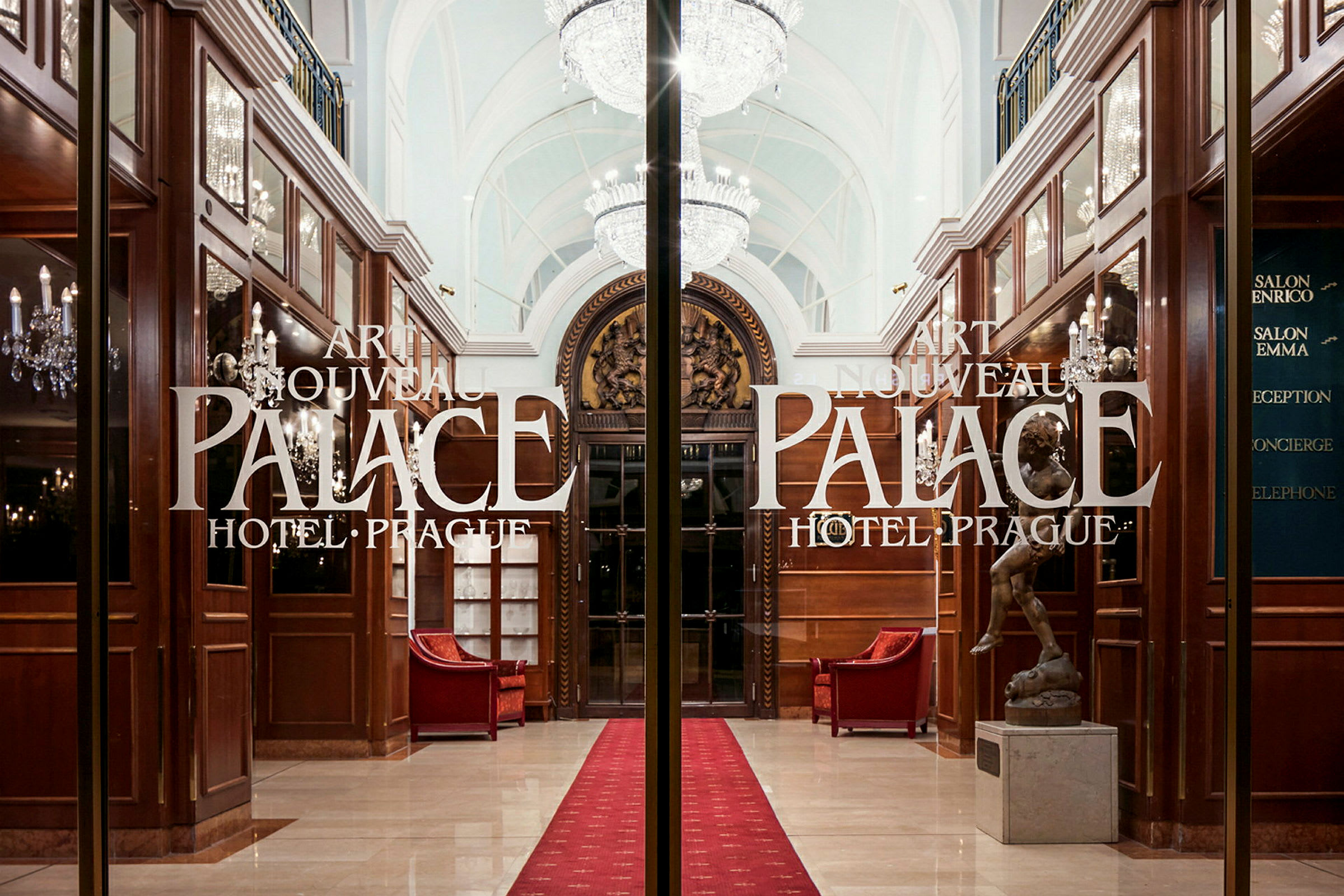 Entré till Art Nouveau Palace Hotel i Prag, med glaserade dörrar och elegant interiör. (AI-genererad text)