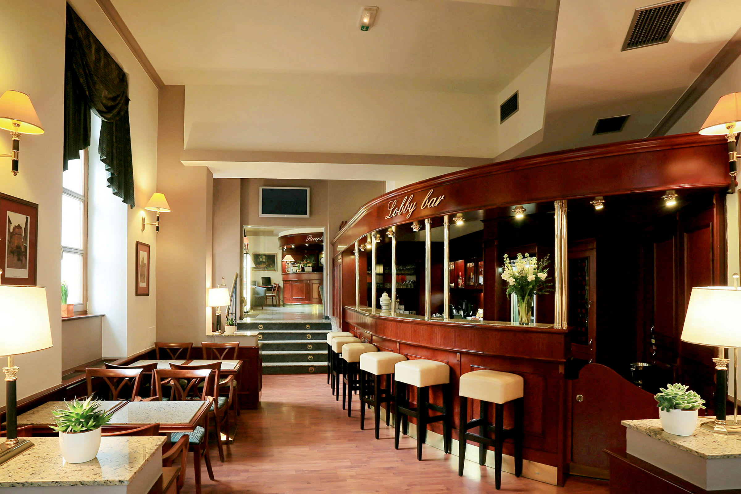 Bild av en lobbybar med träinredning, stolar vid disken och bord för sittplatser. (AI-genererad text)