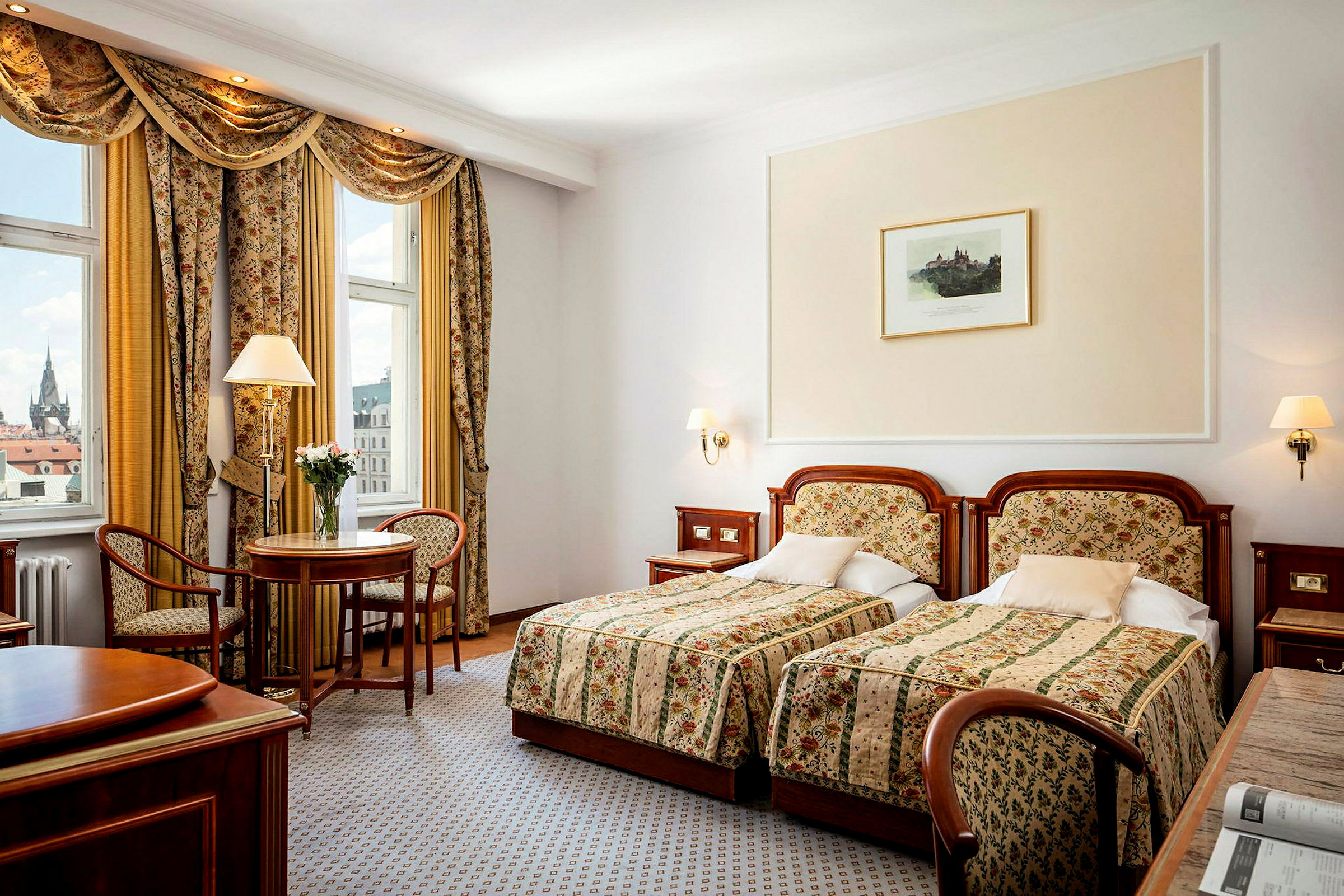 Ett hotellrum med två enkelsängar, ett litet bord med två stolar och fönster med utsikt. (AI-genererad text)