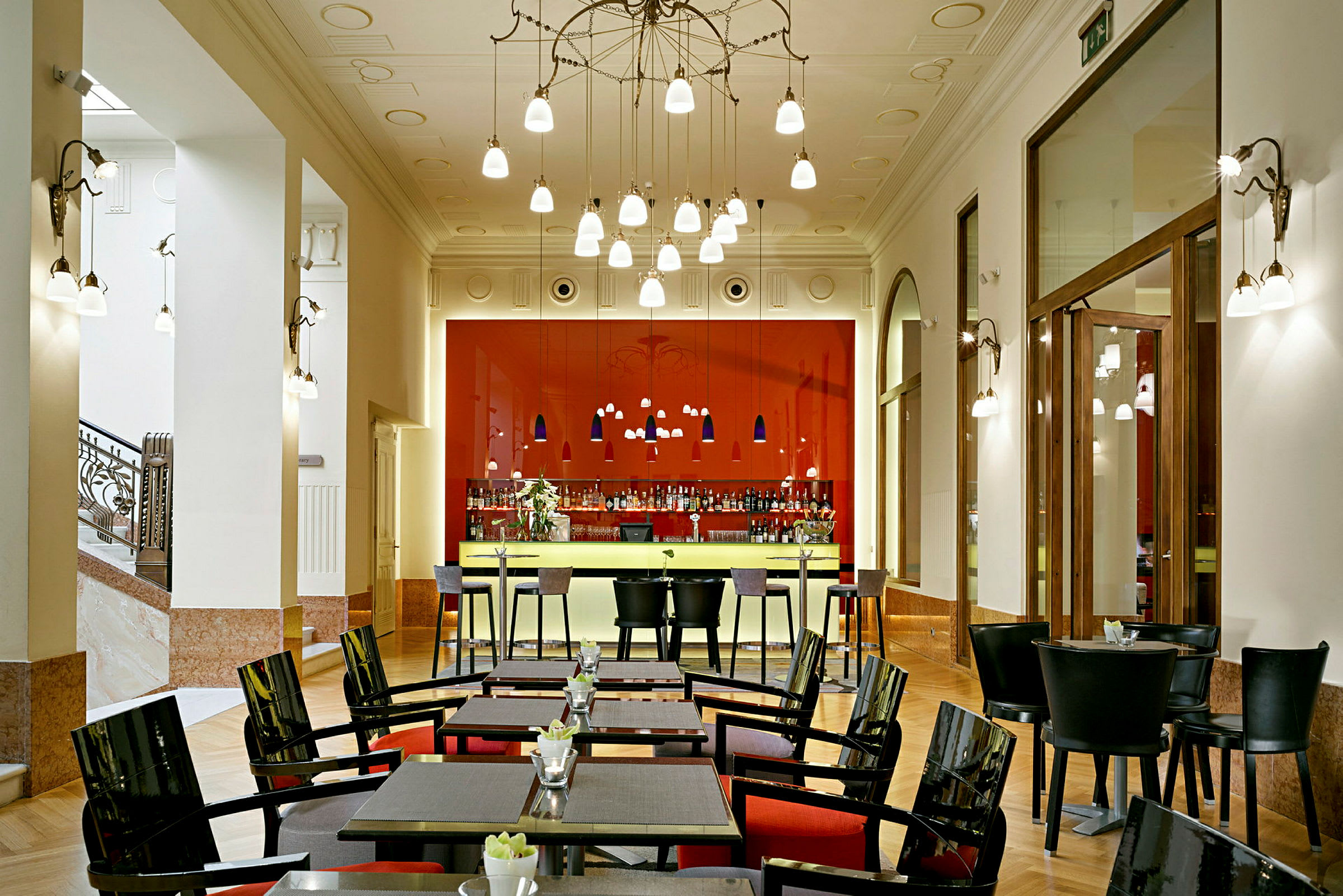 Bild av en elegant bar och restaurang med röda detaljer, moderna möbler och dekorativa lampor. (AI-genererad text)