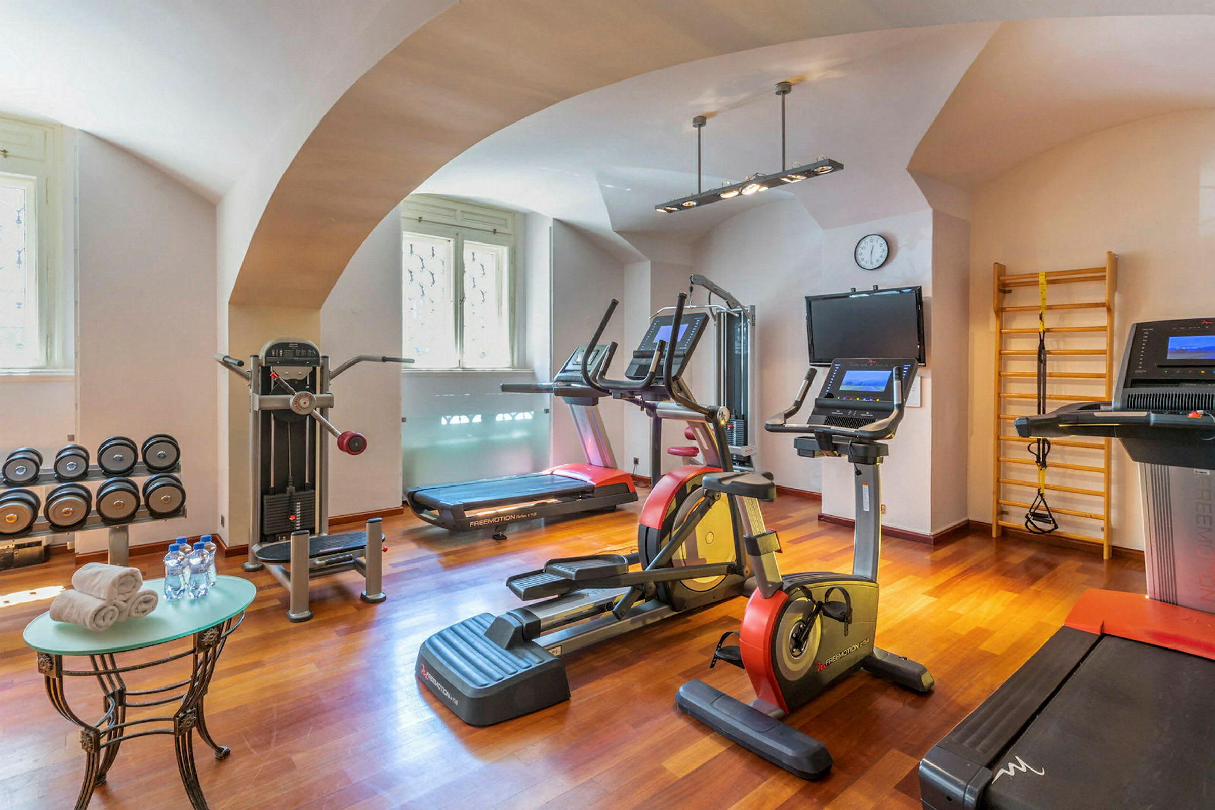 Ett gym med träningsmaskiner, hantlar och annan utrustning. (AI-genererad text)