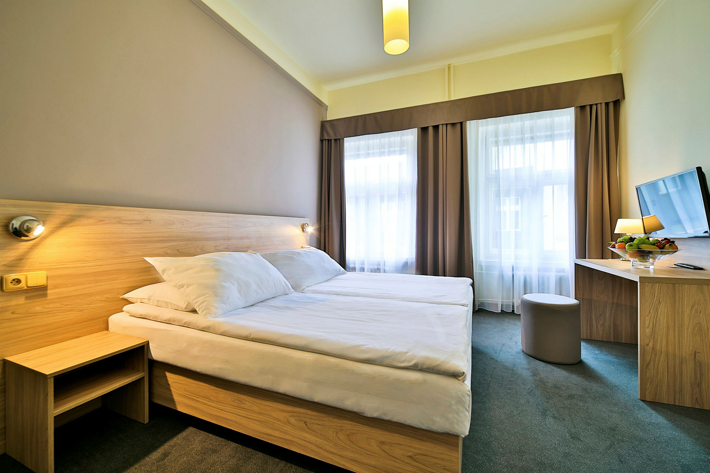 Ett hotellrum med två enkelsängar och ett bord med en stol. (AI-genererad text)