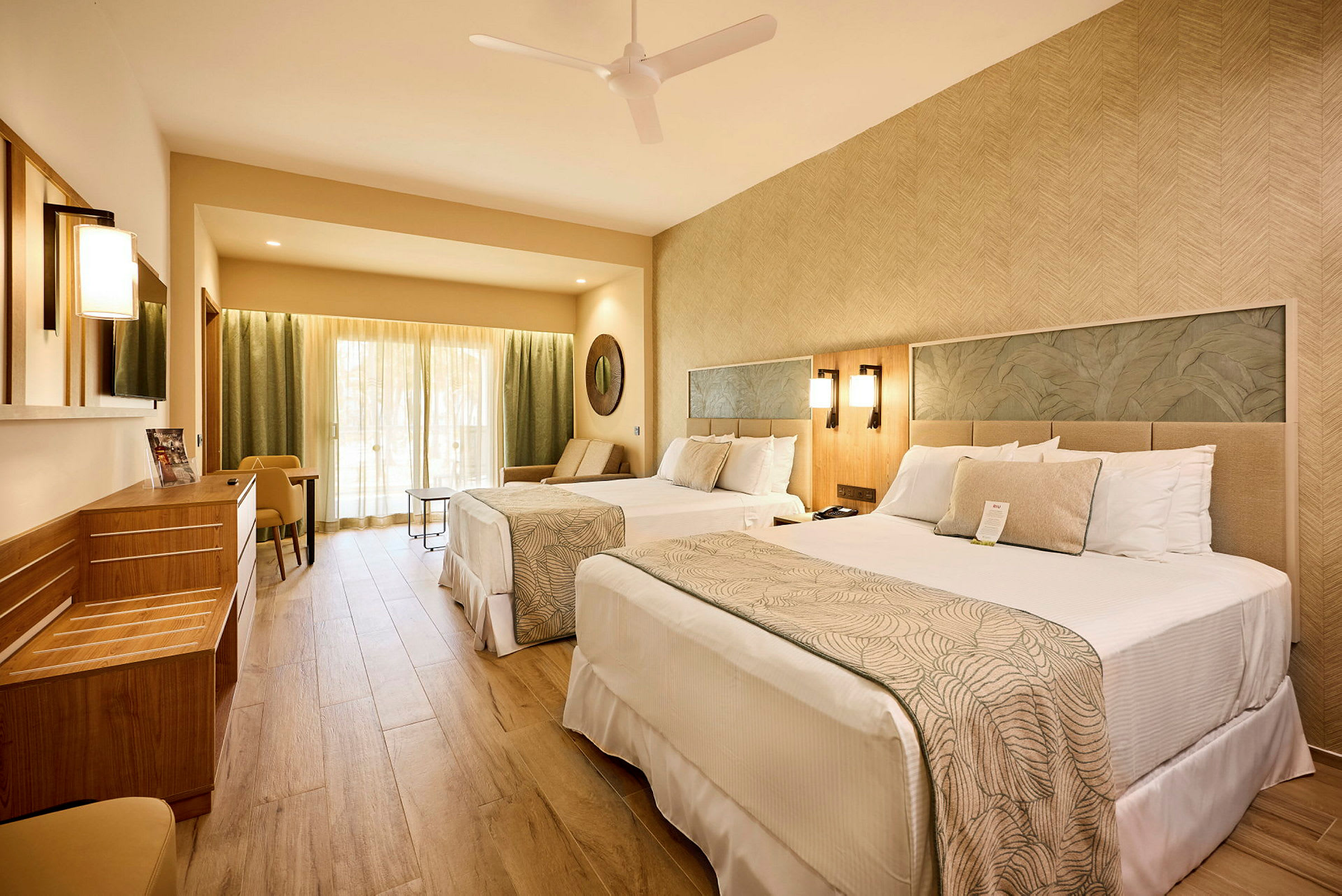 Hotellrum med två sängar, sittgrupp och ljusa möbler. (AI-genererad text)