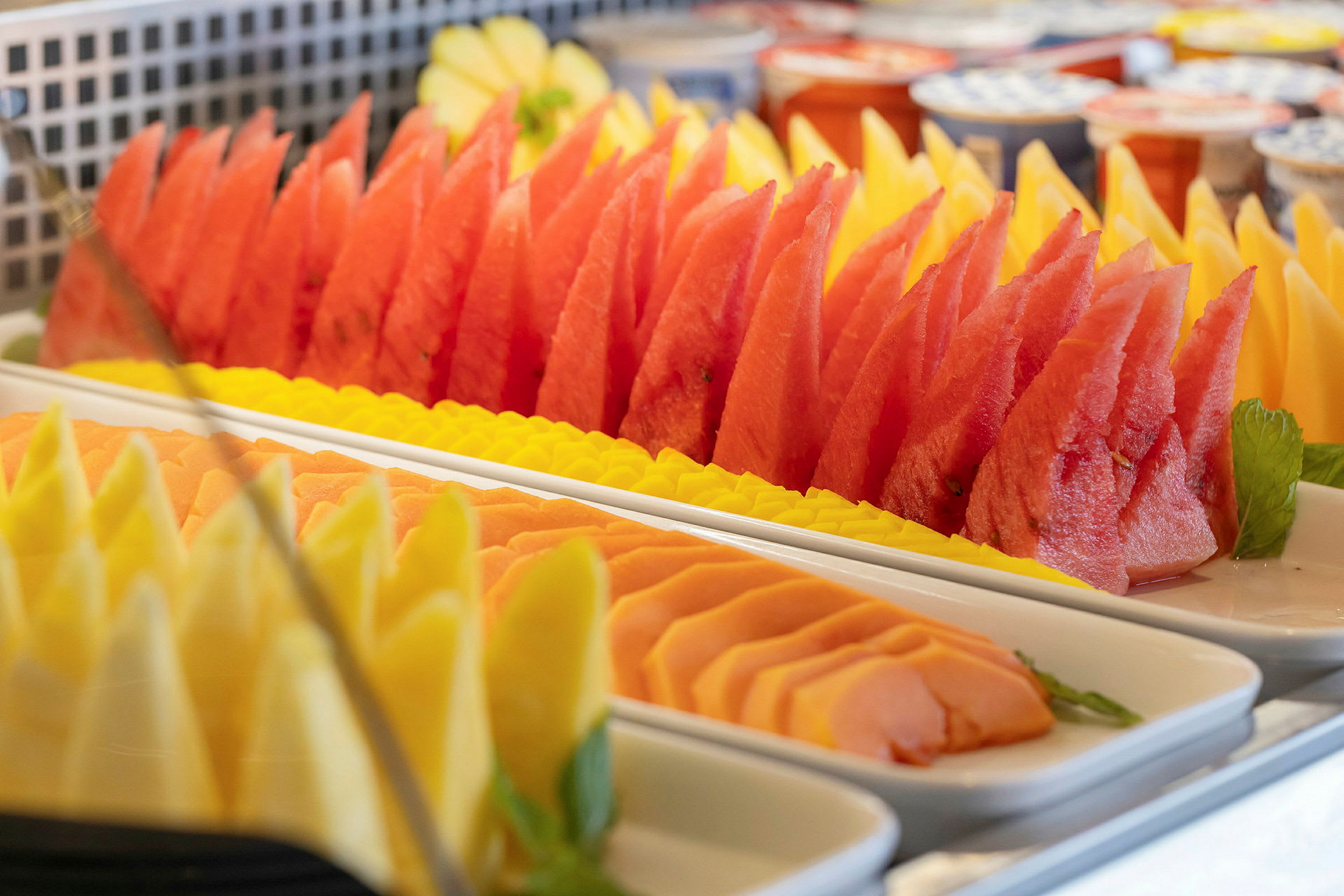 Skuren frukt som melon, papaya och ananas upplagd på fat. (AI-genererad text)
