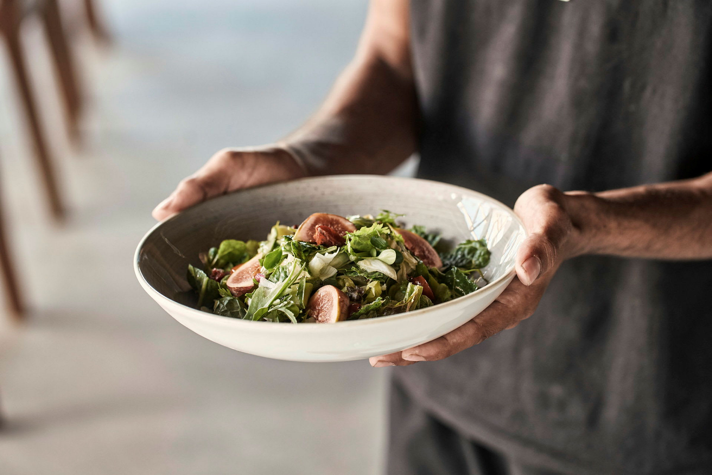 En person håller en skål med sallad. (AI-genererad text)