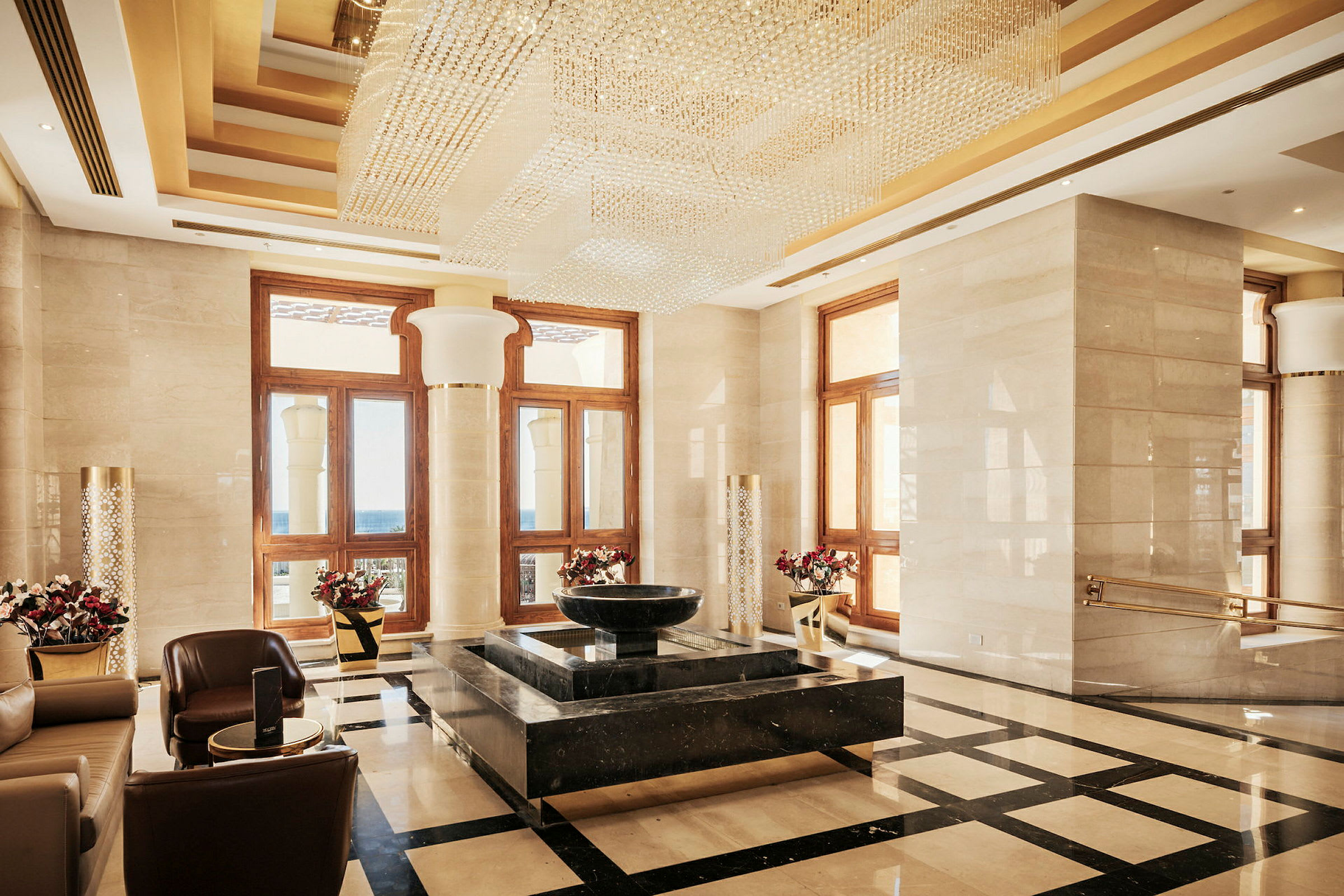 Ett elegant inrett hotellfoajé med en stor ljuskrona, marmorgolv och exklusiva möbler. (AI-genererad text)