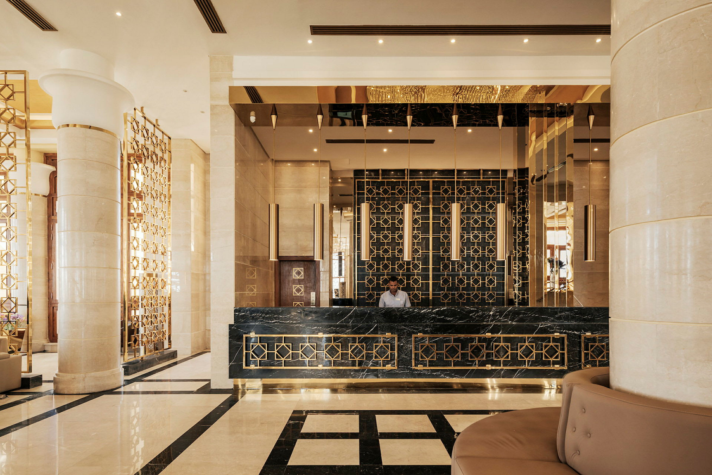 En hotellreception med en elegant och modern design, inklusive marmorgolv och gulddetaljer. (AI-genererad text)
