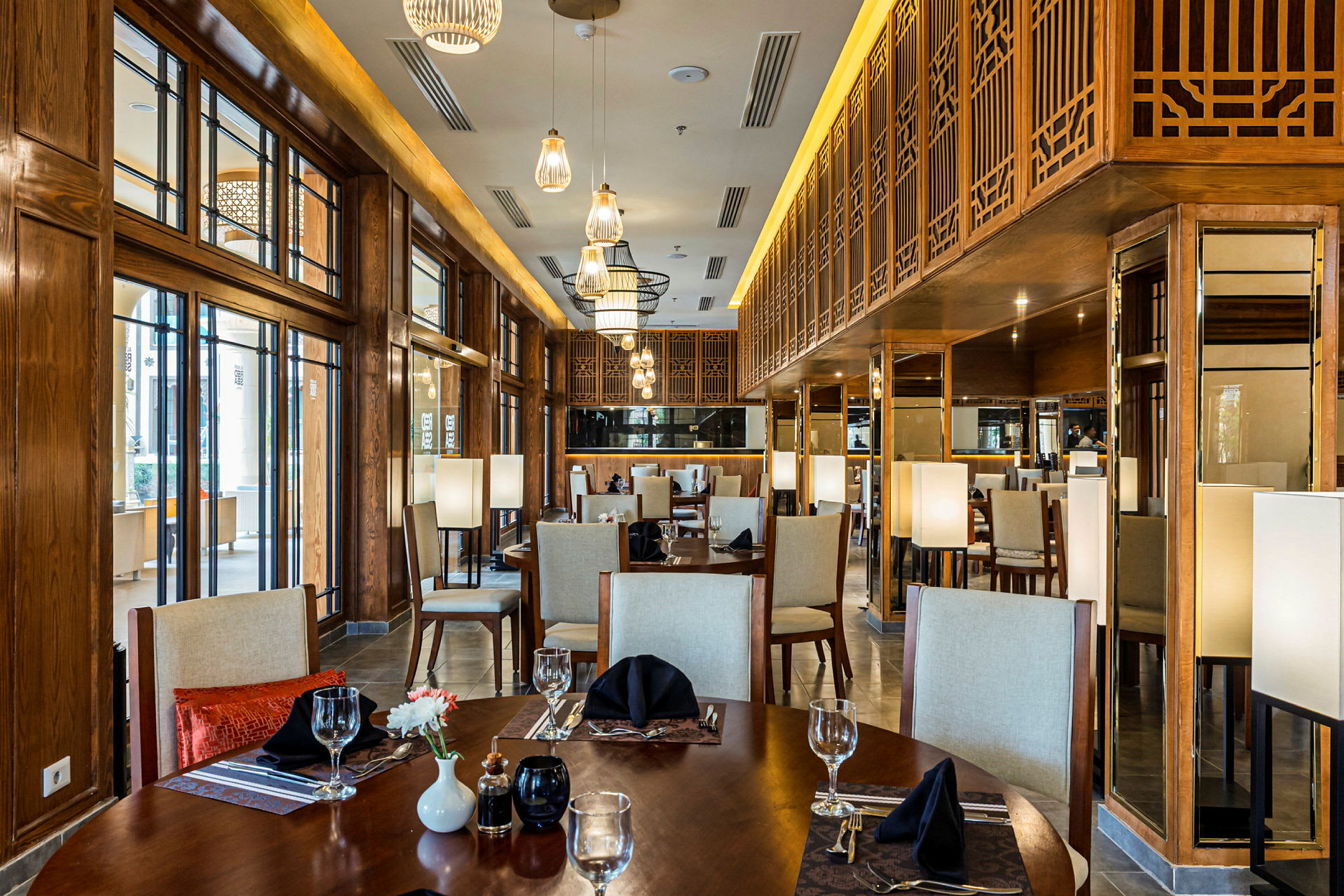 Bild av en elegant restaurang med träinredning, designbelysning och dukade bord. (AI-genererad text)