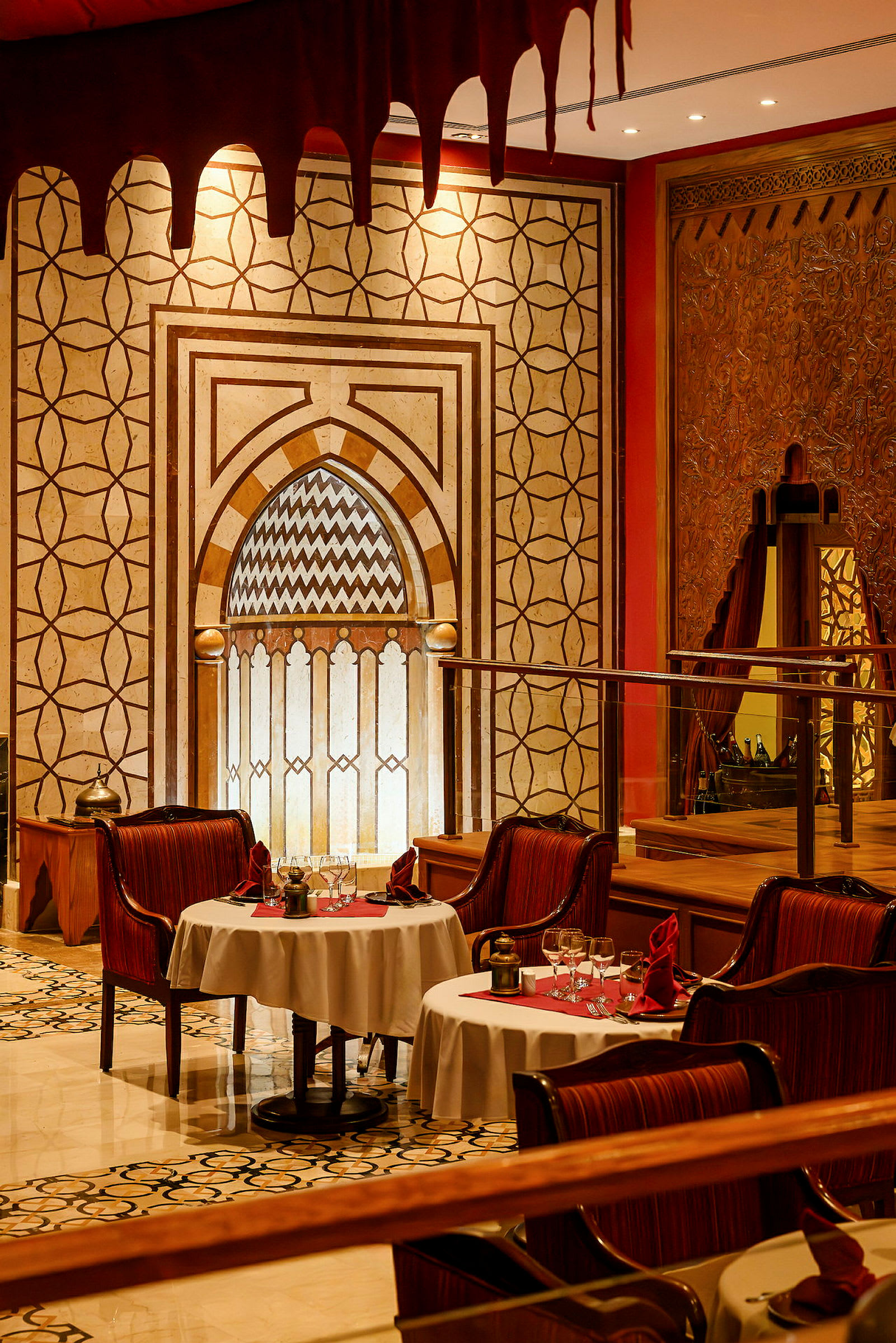 En restaurang med orientaliskt inspirerad inredning, bord med vita dukar och röda detaljer. (AI-genererad text)