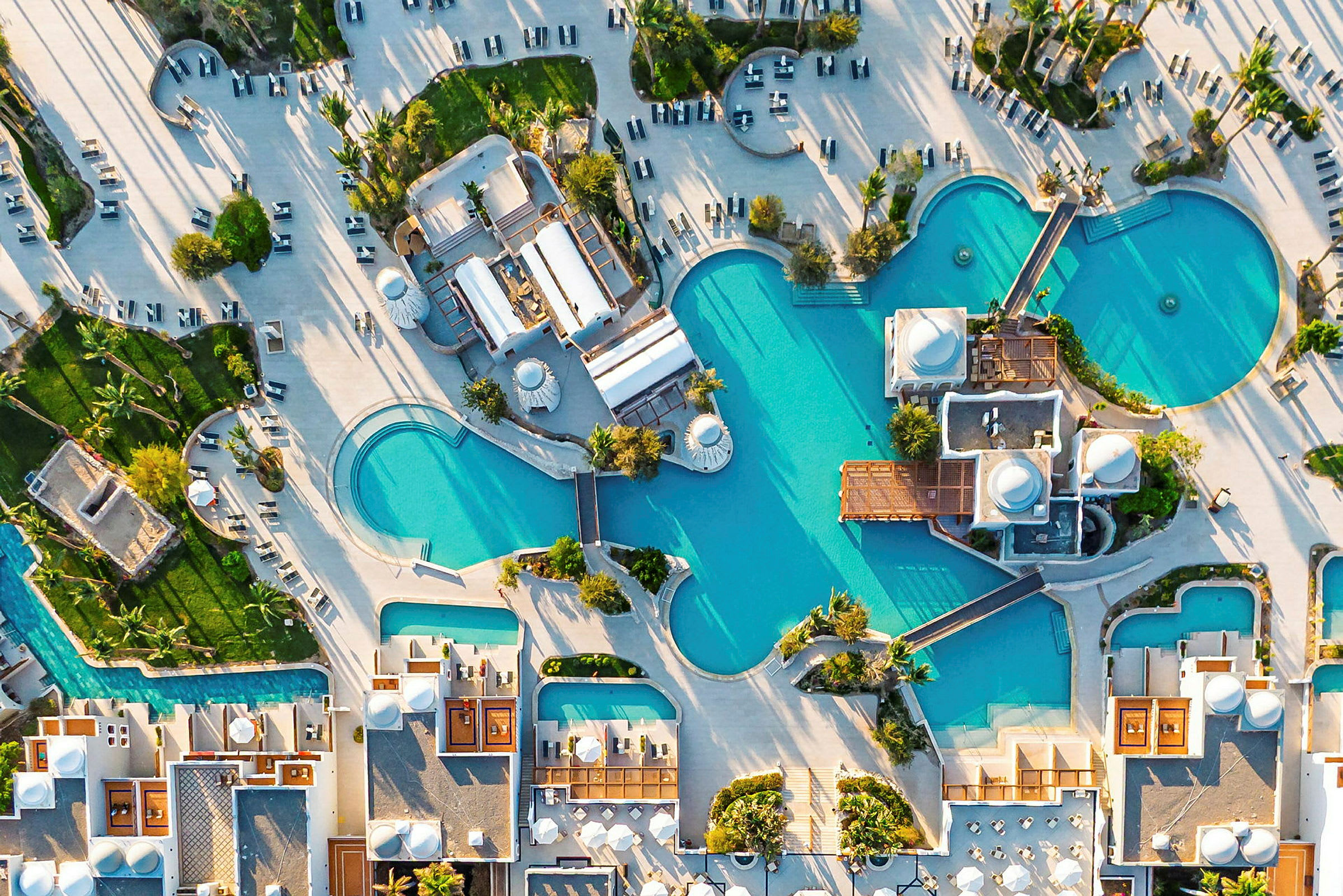 Flygfoto över poolområde med omgivande byggnader och grönska. (AI-genererad text)