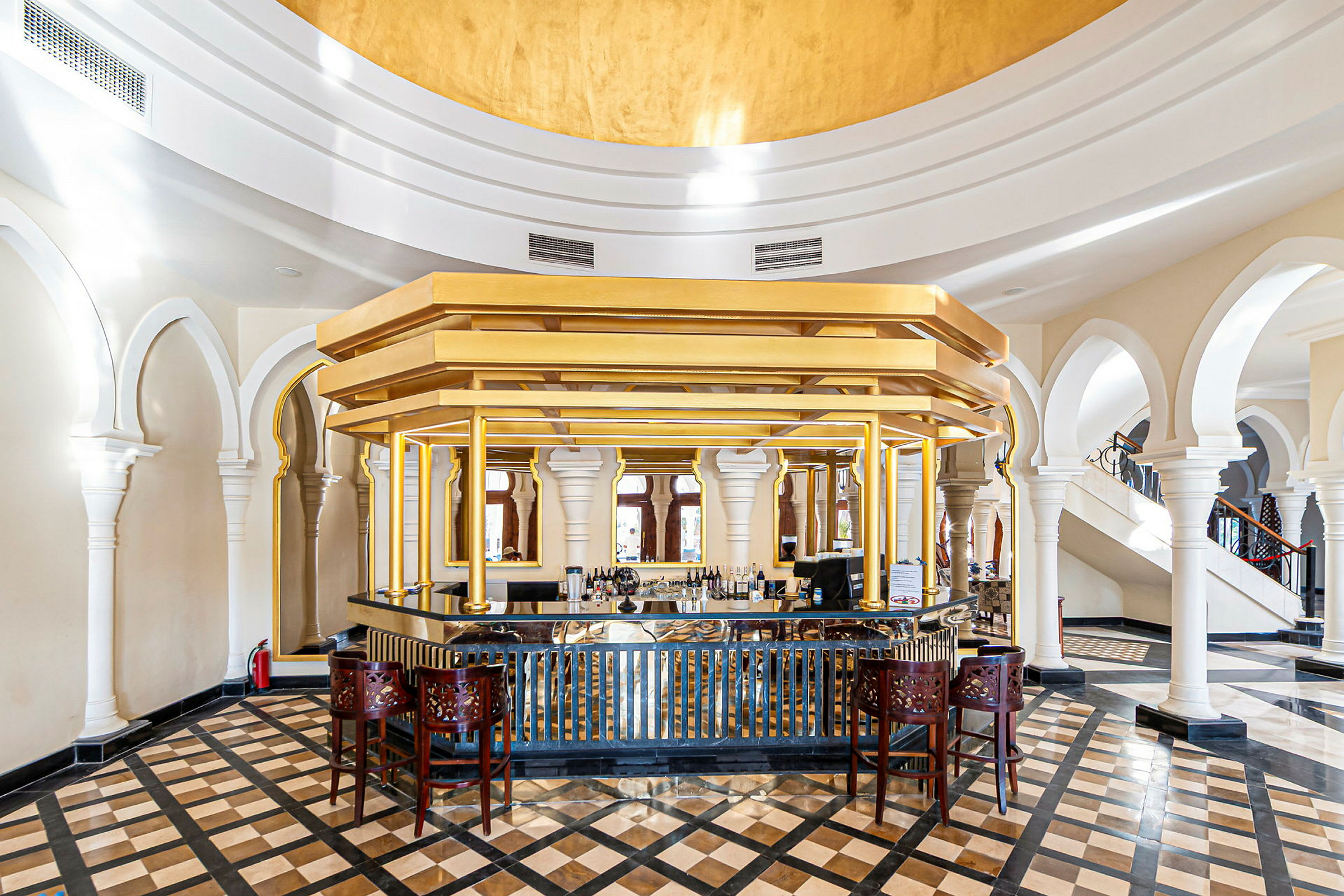 En elegant hotellbar med gulddetaljer och marmorgolv. (AI-genererad text)