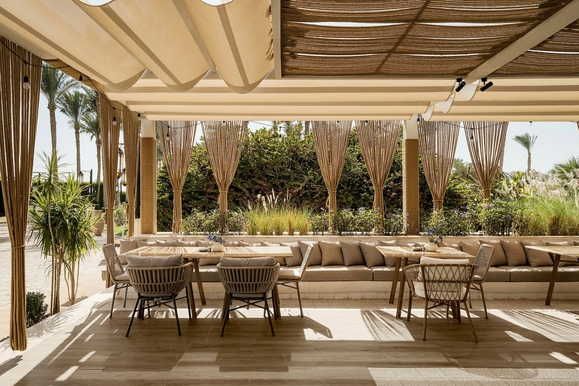 En smakfull restaurangterrass med bekväma möbler och en vacker utsikt över grönska. (AI-genererad text)