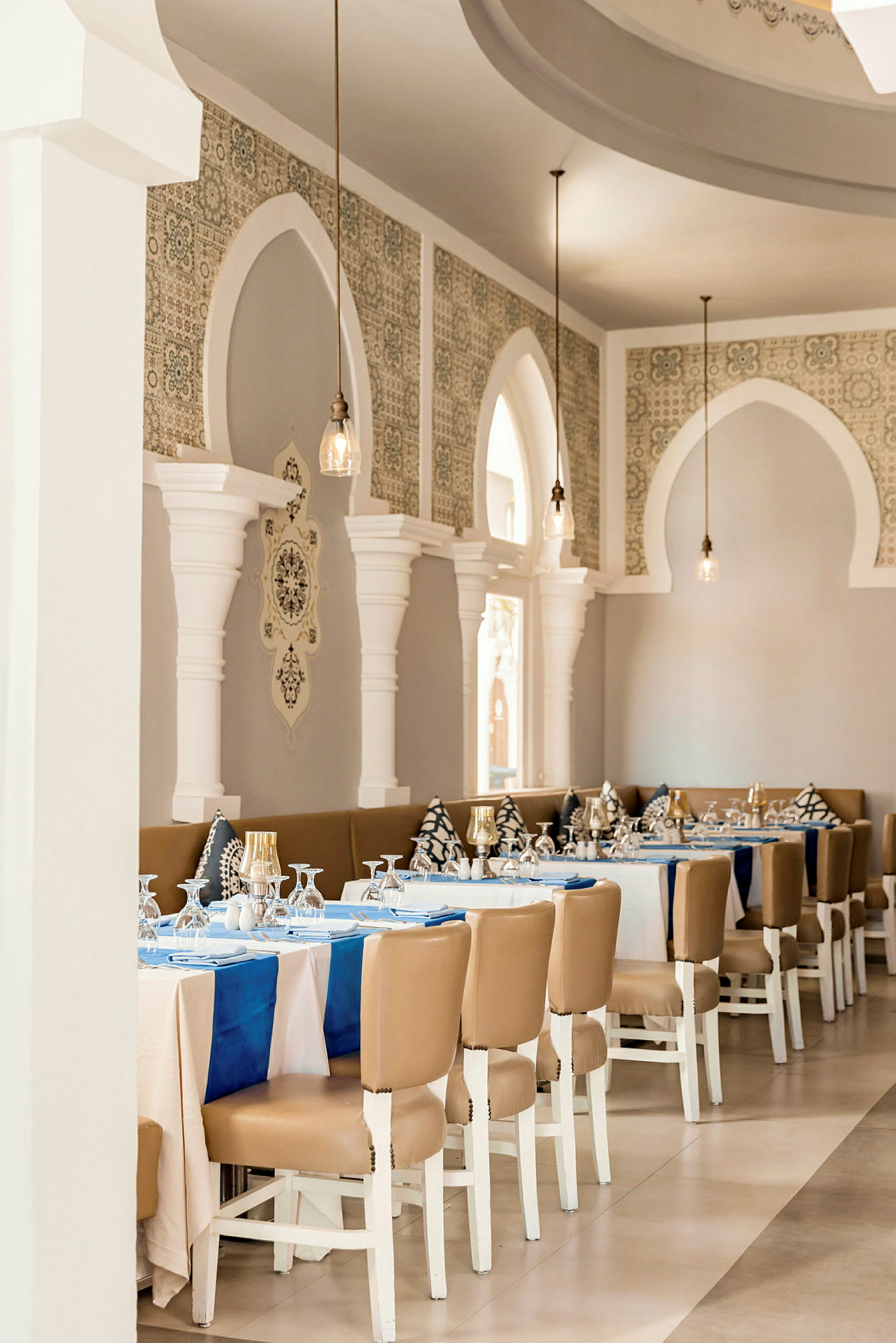 En elegant restaurang med dukade bord, vita väggar och dekorativa bågar. (AI-genererad text)