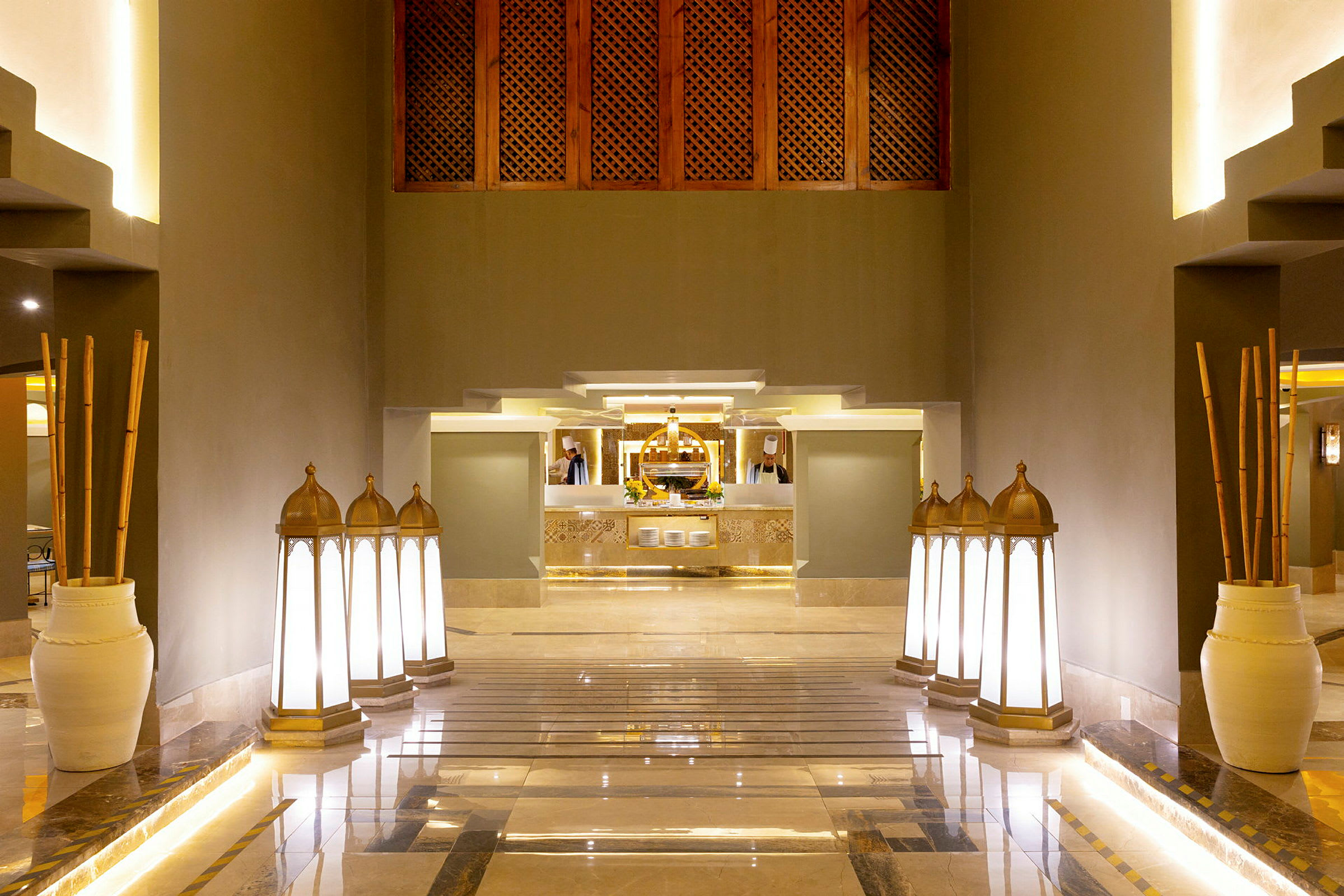 Ett elegant hotellinteriör med en central reception i bakgrunden. Dekorationer som lampor och keramiska vaser syns längs golvet. (AI-genererad text)