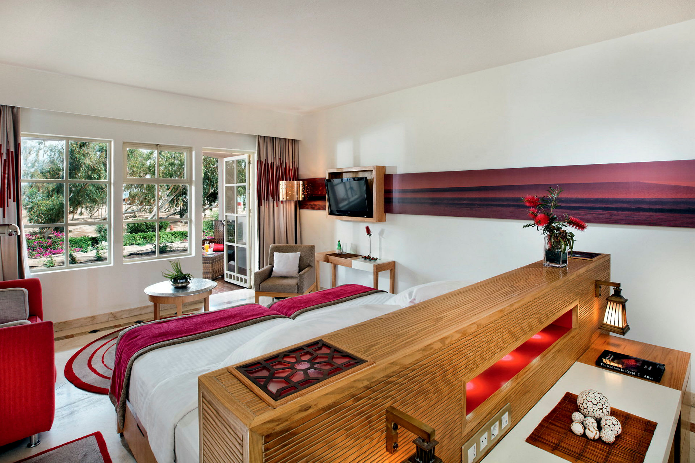 Hotellrum med modern inredning och stora fönster mot trädgård. (AI-genererad text)