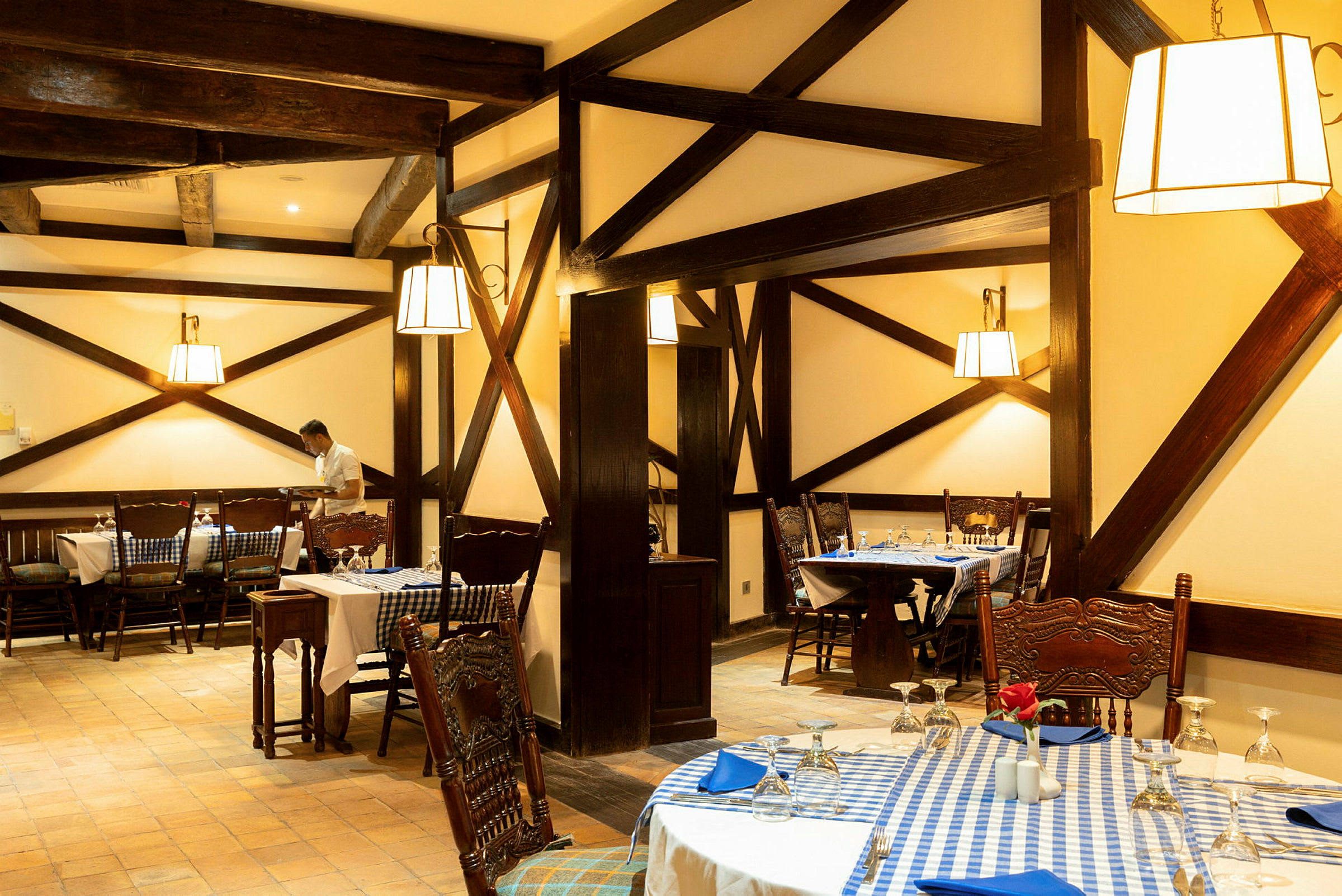 En restaurang med rustik inredning och bord klädda med blåvitrutiga dukar. (AI-genererad text)