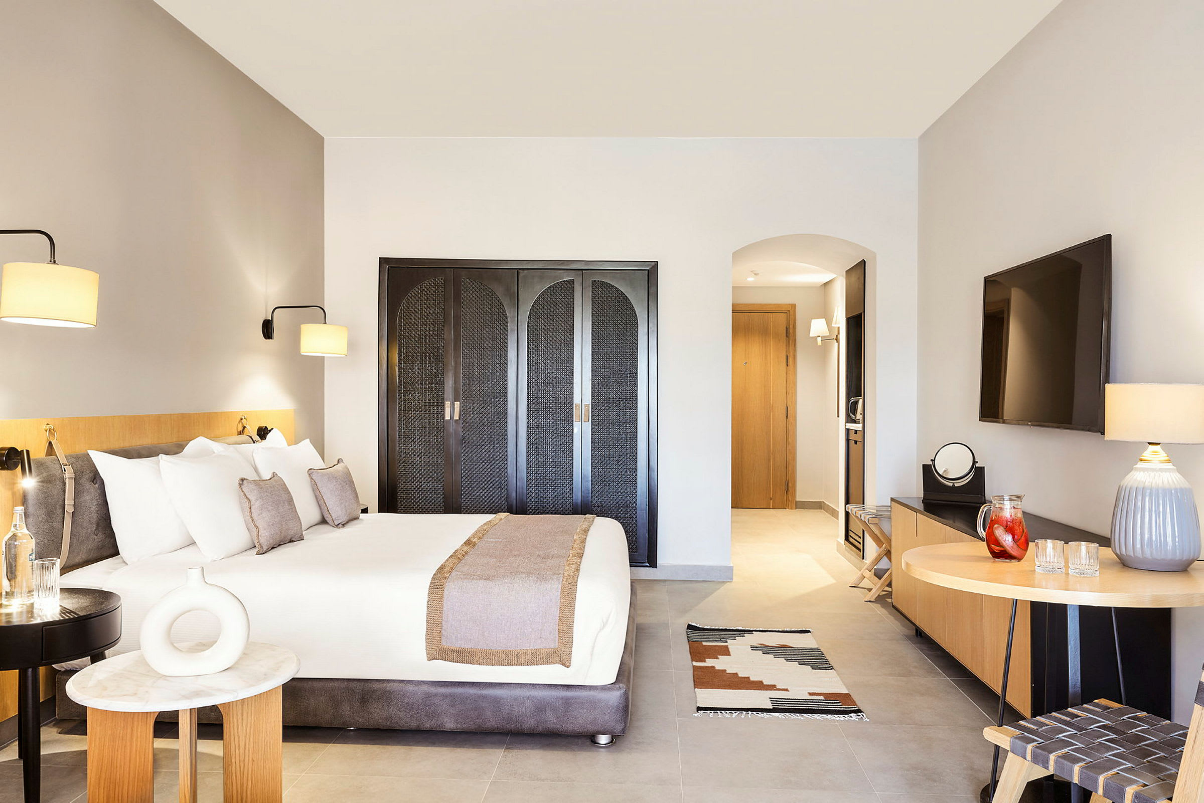 Hotellrum med dubbelsäng, TV och inredning. (AI-genererad text)