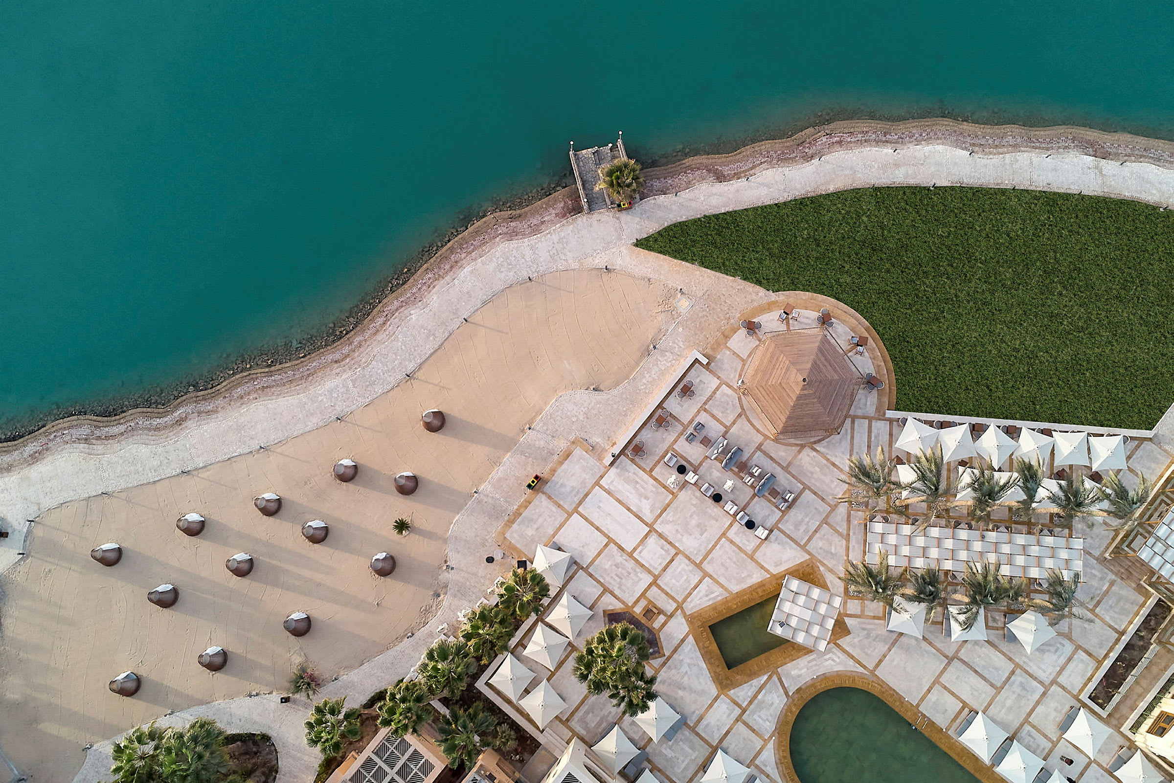 Flygbild av en resort med strand vid vatten. (AI-genererad text)