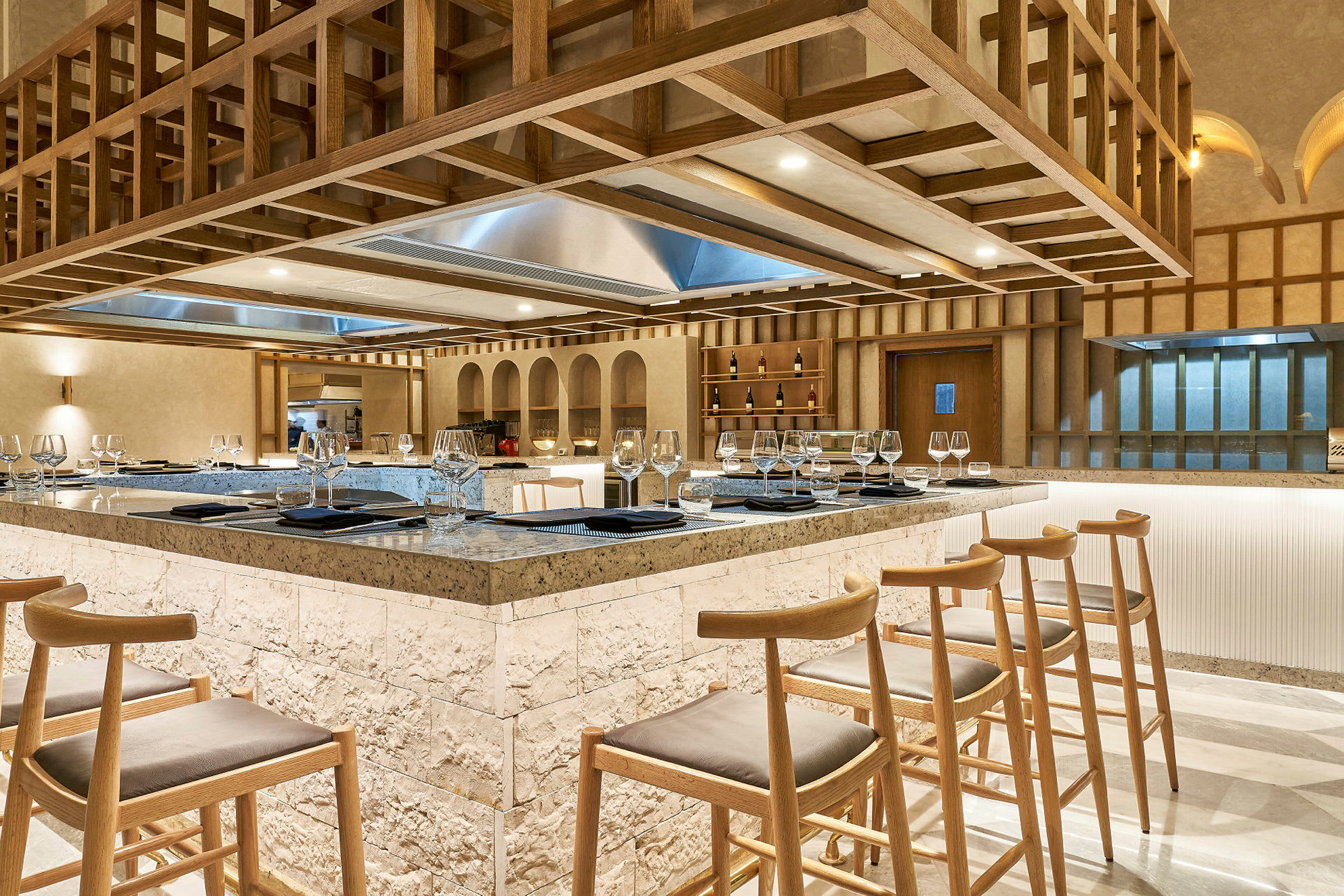 En elegant restaurang med en central bardisk omgiven av höga trästolar. (AI-genererad text)