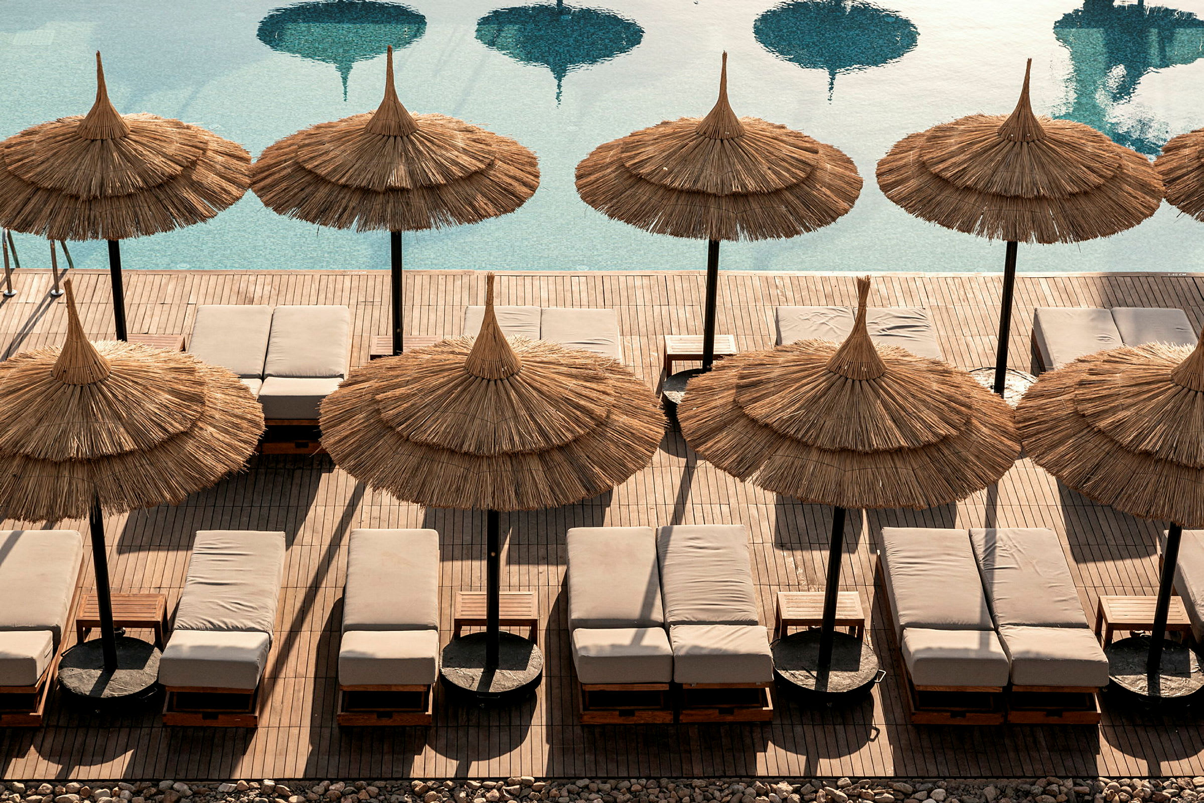 Solstolar och parasoll vid en pool. (AI-genererad text)