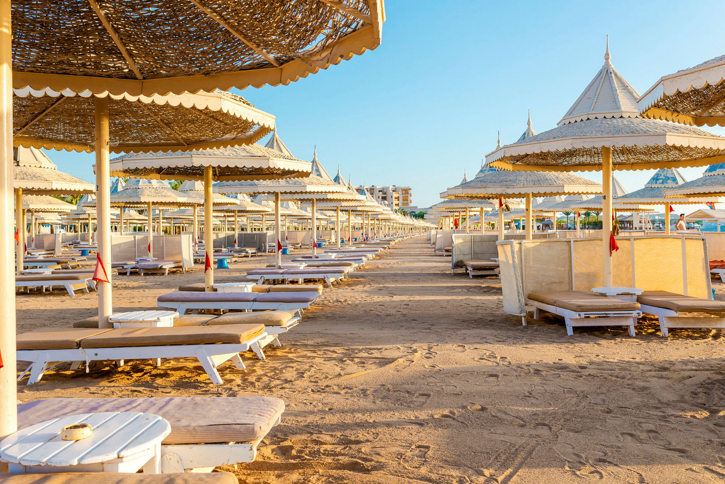 Solstolar och parasoller på en sandstrand. (AI-genererad text)