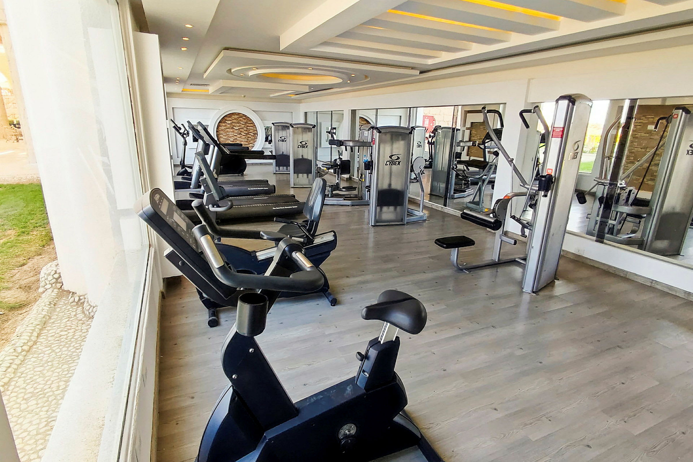 Bild av ett gym med olika träningsmaskiner och spegelväggar. (AI-genererad text)