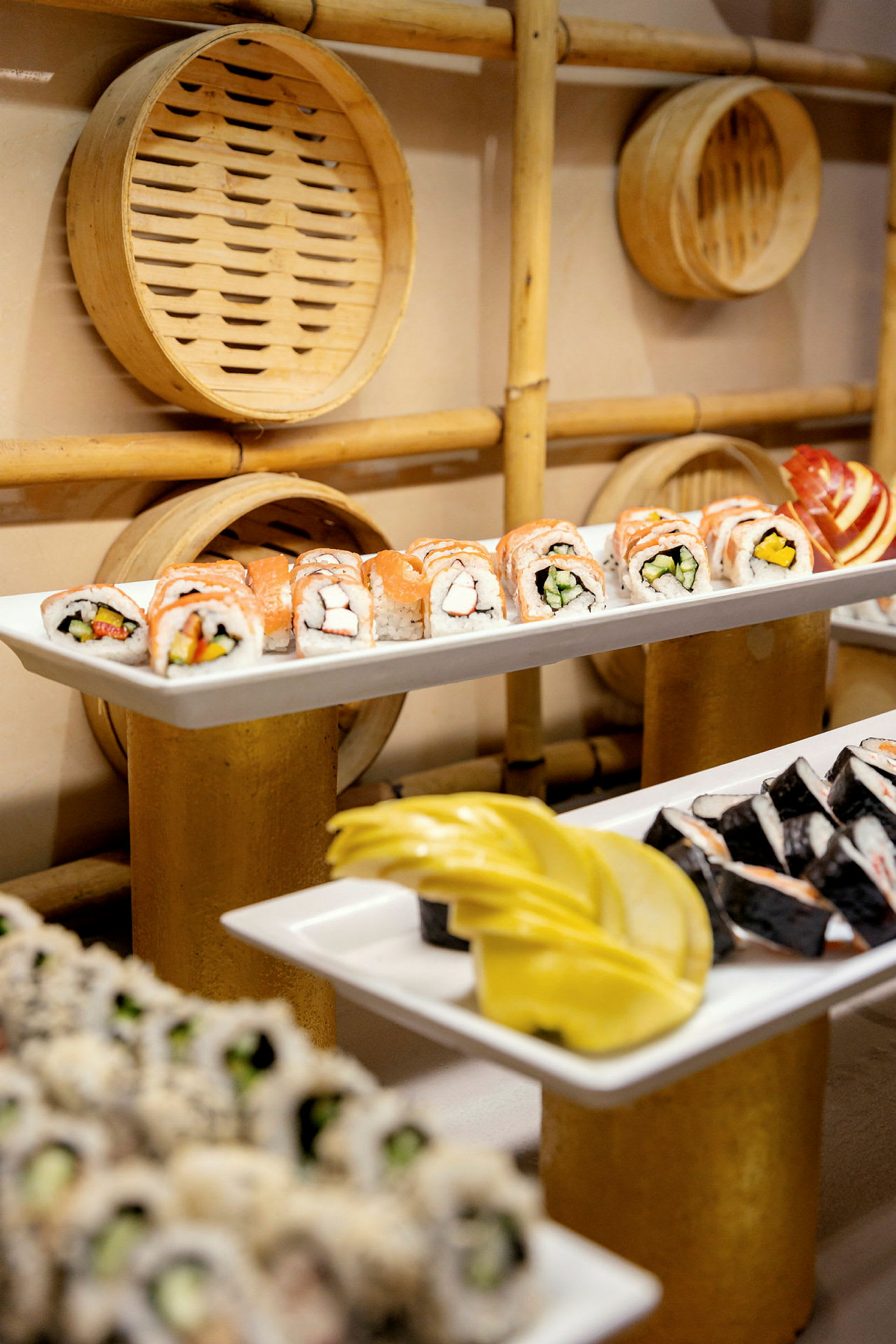 Tallrikar med sushi och dekorationer i bambu på bakväggen. (AI-genererad text)