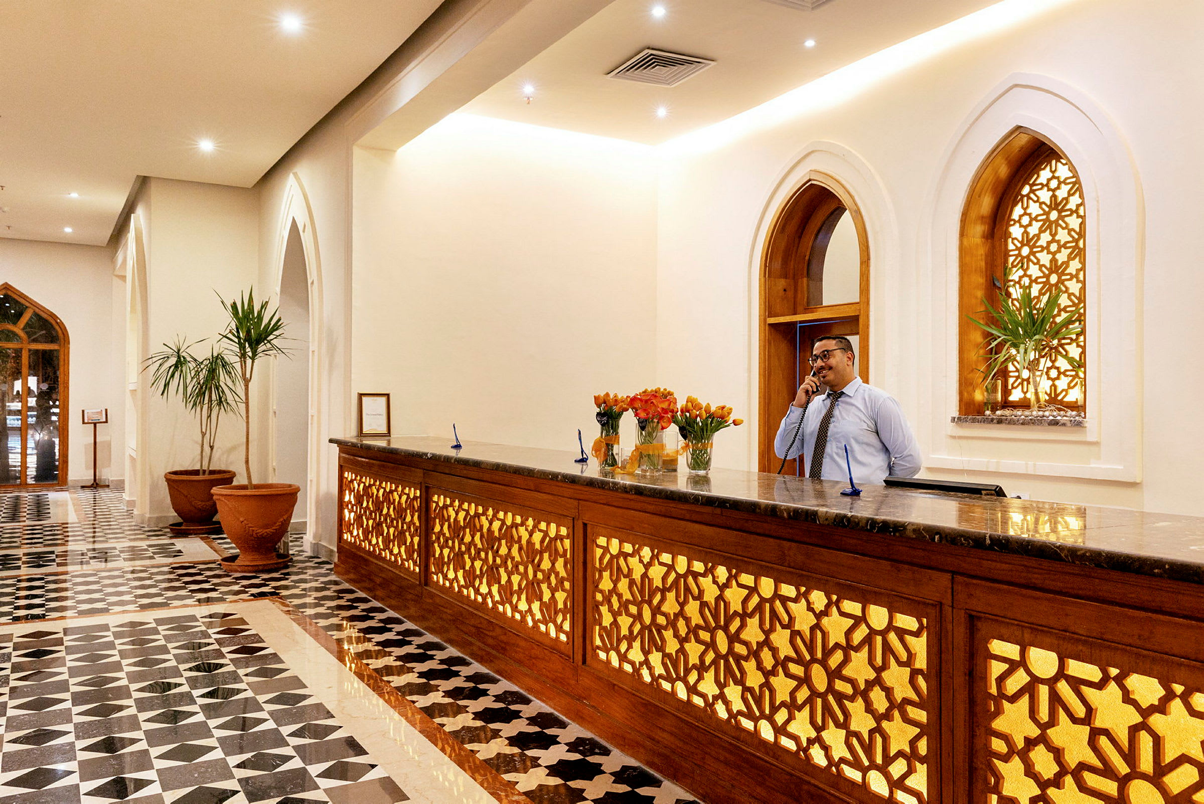 Hotelllobbyn med receptionsdisk och dekorativa fönster. (AI-genererad text)