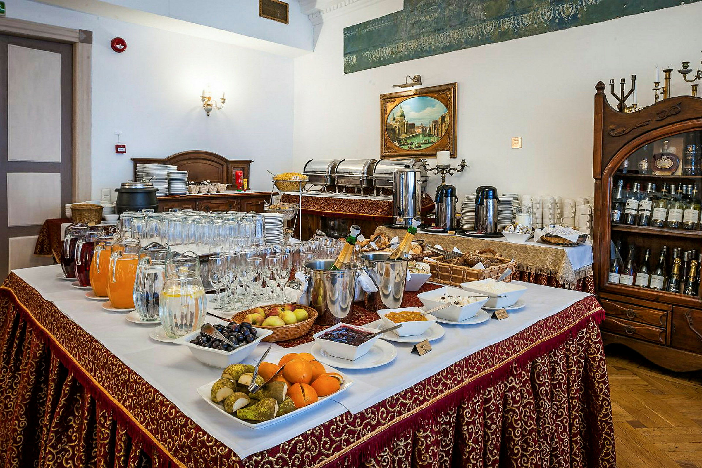 Ett buffébord med olika drycker, frukter och tilltugg uppdukat i en elegant restaurang. (AI-genererad text)