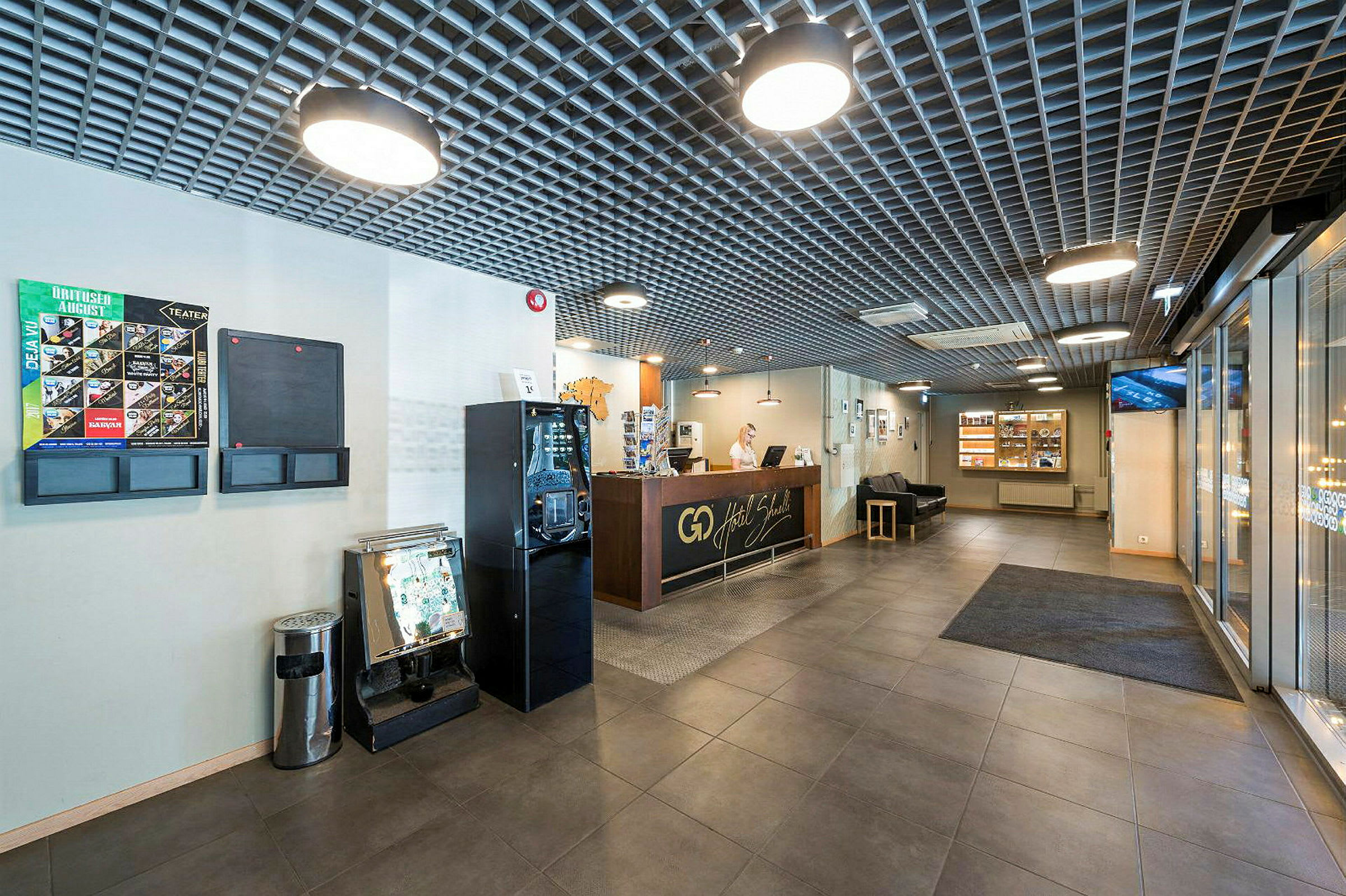 Reception på ett hotell med sittgrupp och broschyrställ. (AI-genererad text)