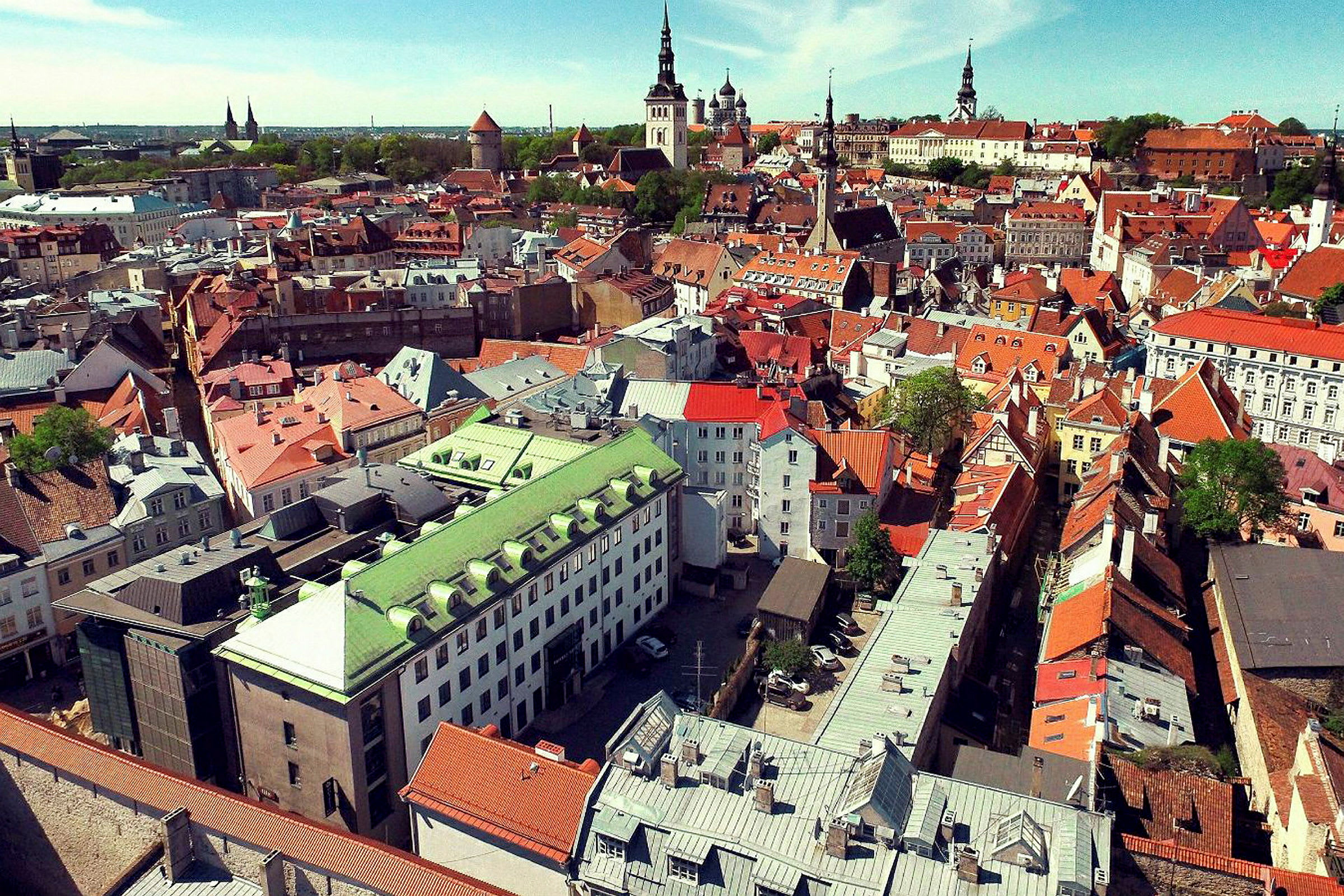 Flygvy över en stad med äldre byggnader i olika färger. (AI-genererad text)